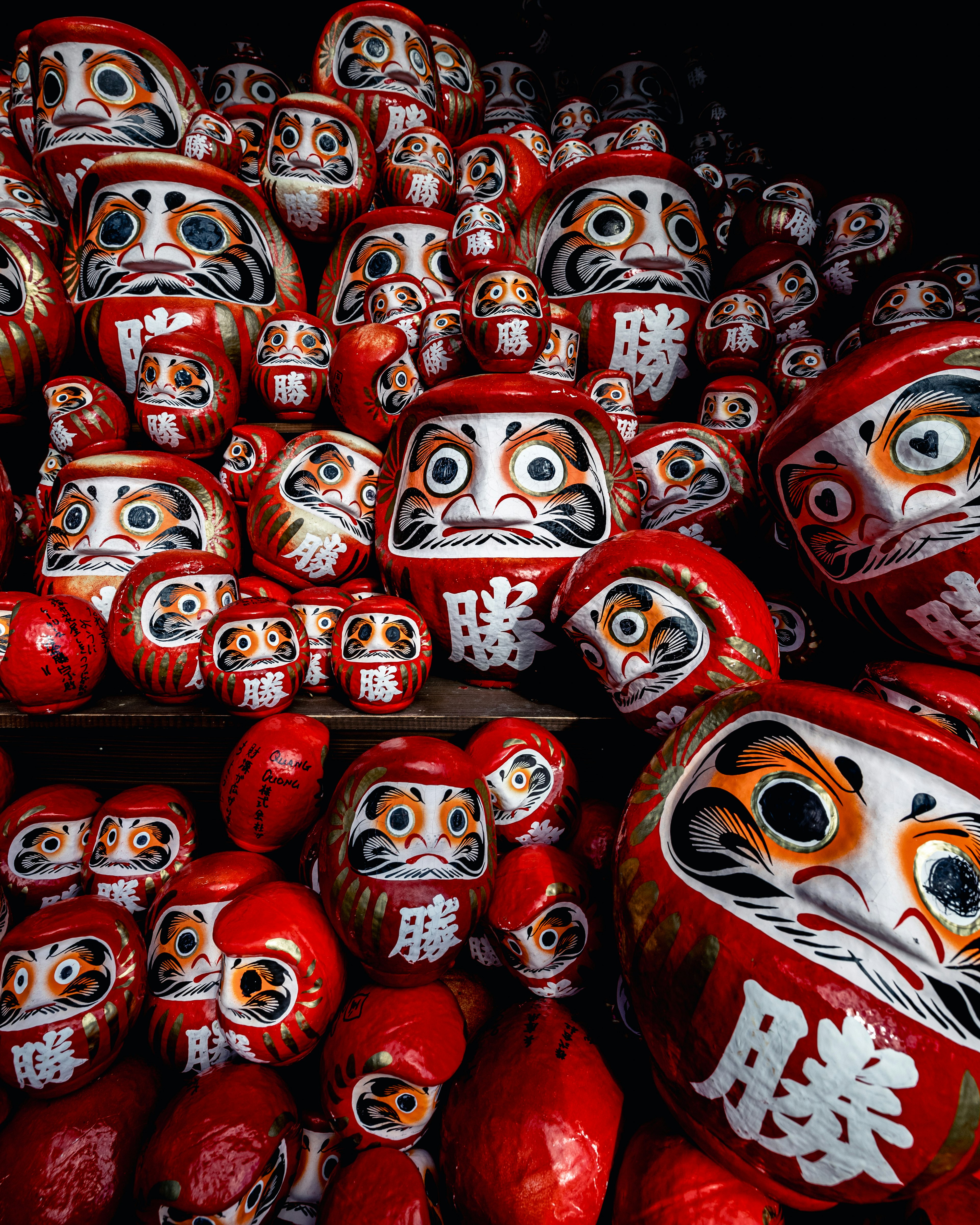 A multitude of red Daruma dolls stacked together