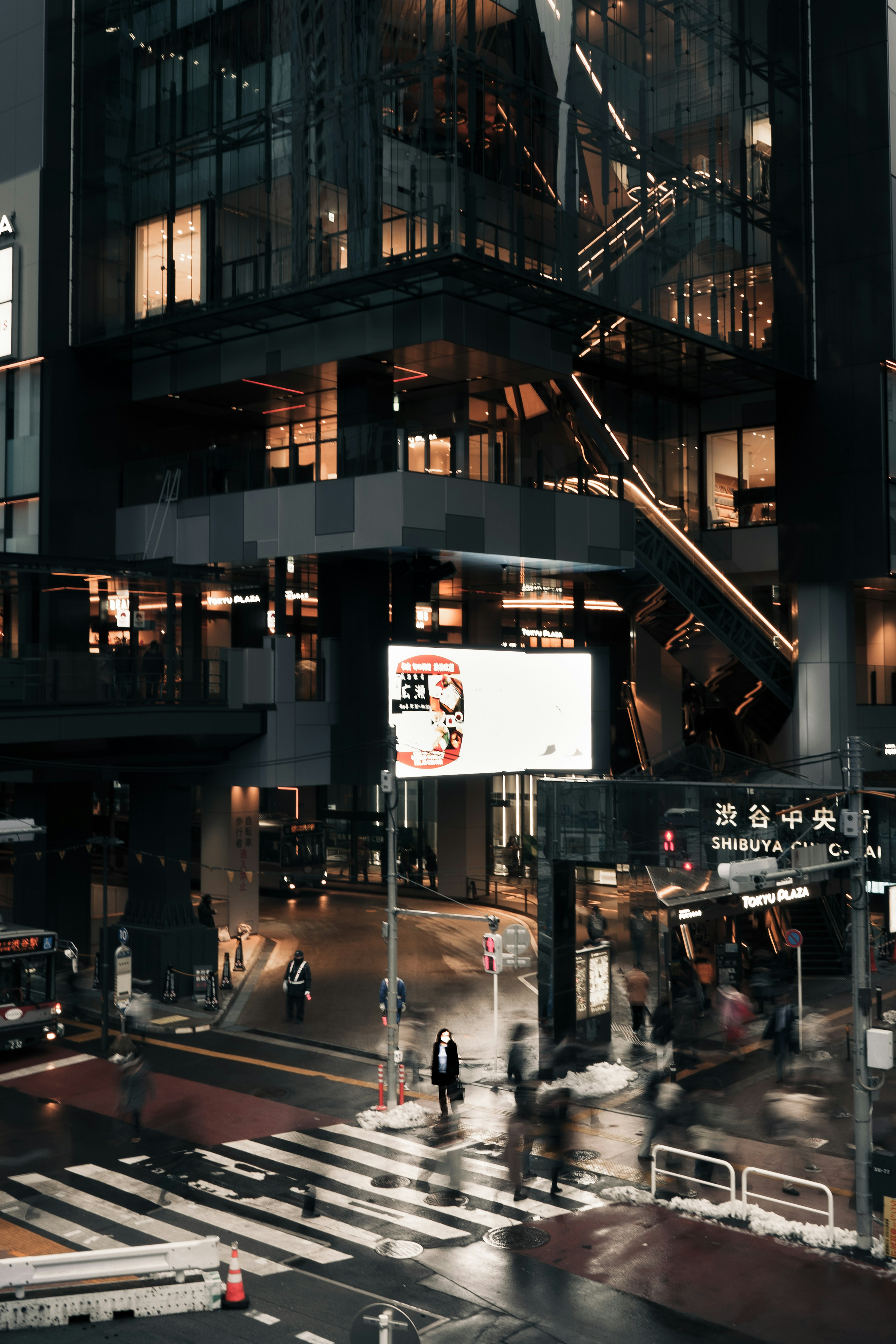 Scène urbaine avec un bâtiment en verre et un passage piéton sous la pluie