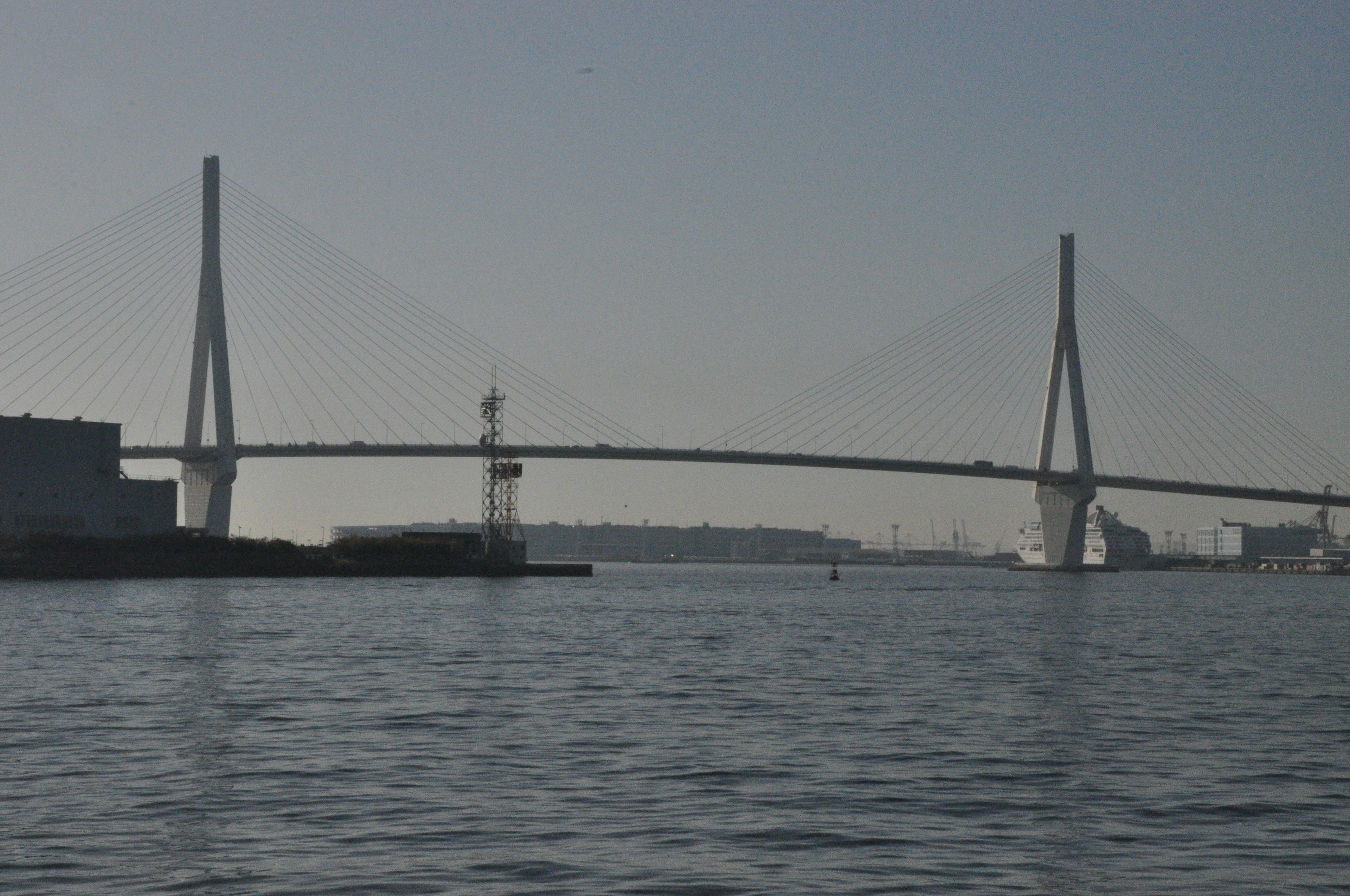 Ponte sospeso moderno che si estende sull'acqua con uno skyline lontano