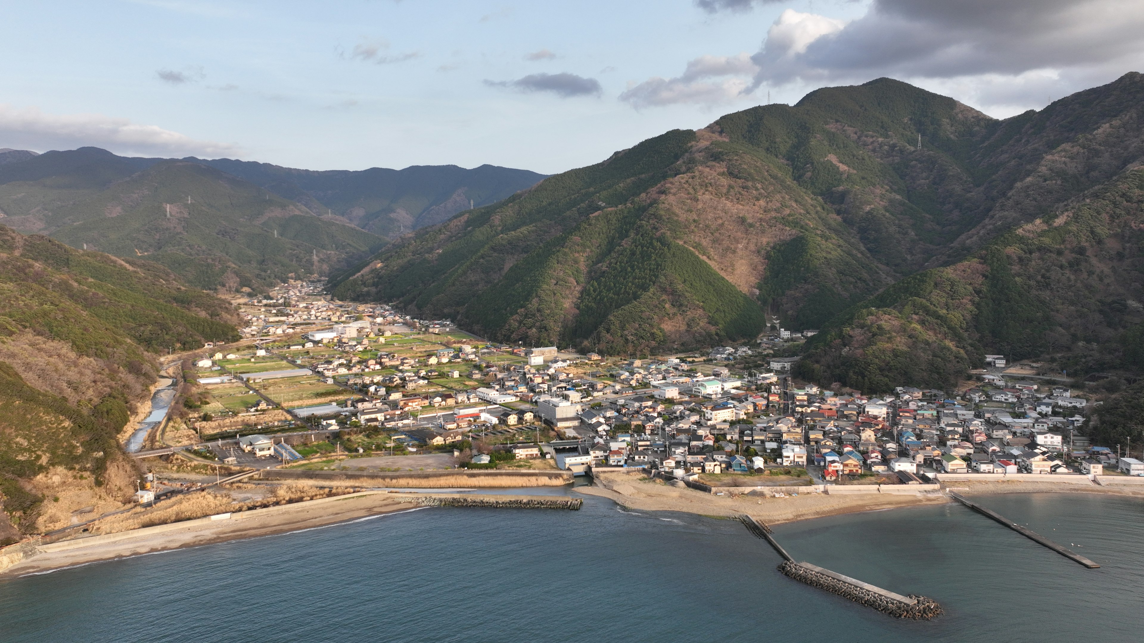 Aerial view of a small town surrounded by mountains and ocean