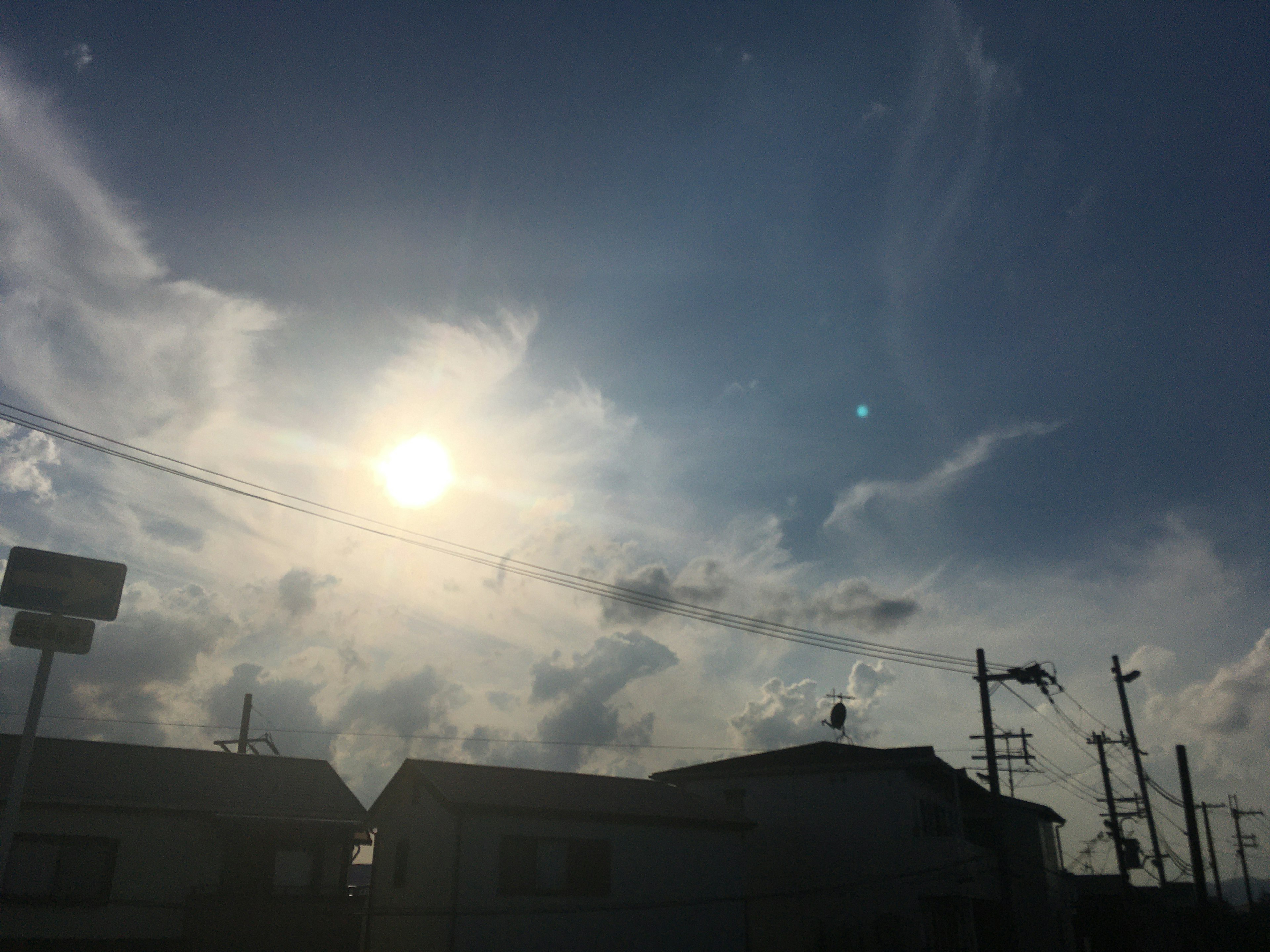 青い空に雲が漂い太陽が輝く風景