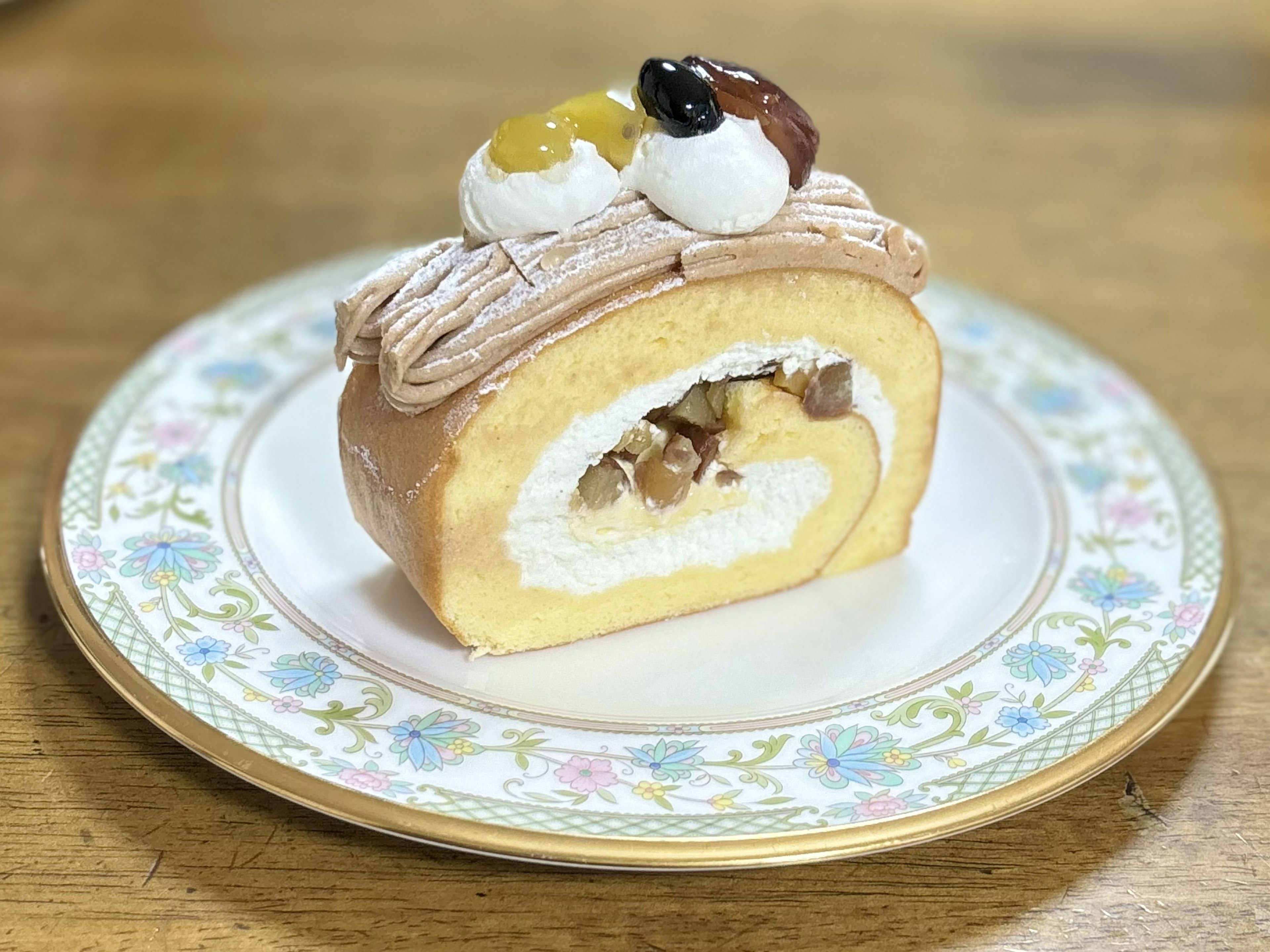 Une belle tranche de gâteau roulé sur une assiette blanche avec de la crème et des noix à l'intérieur