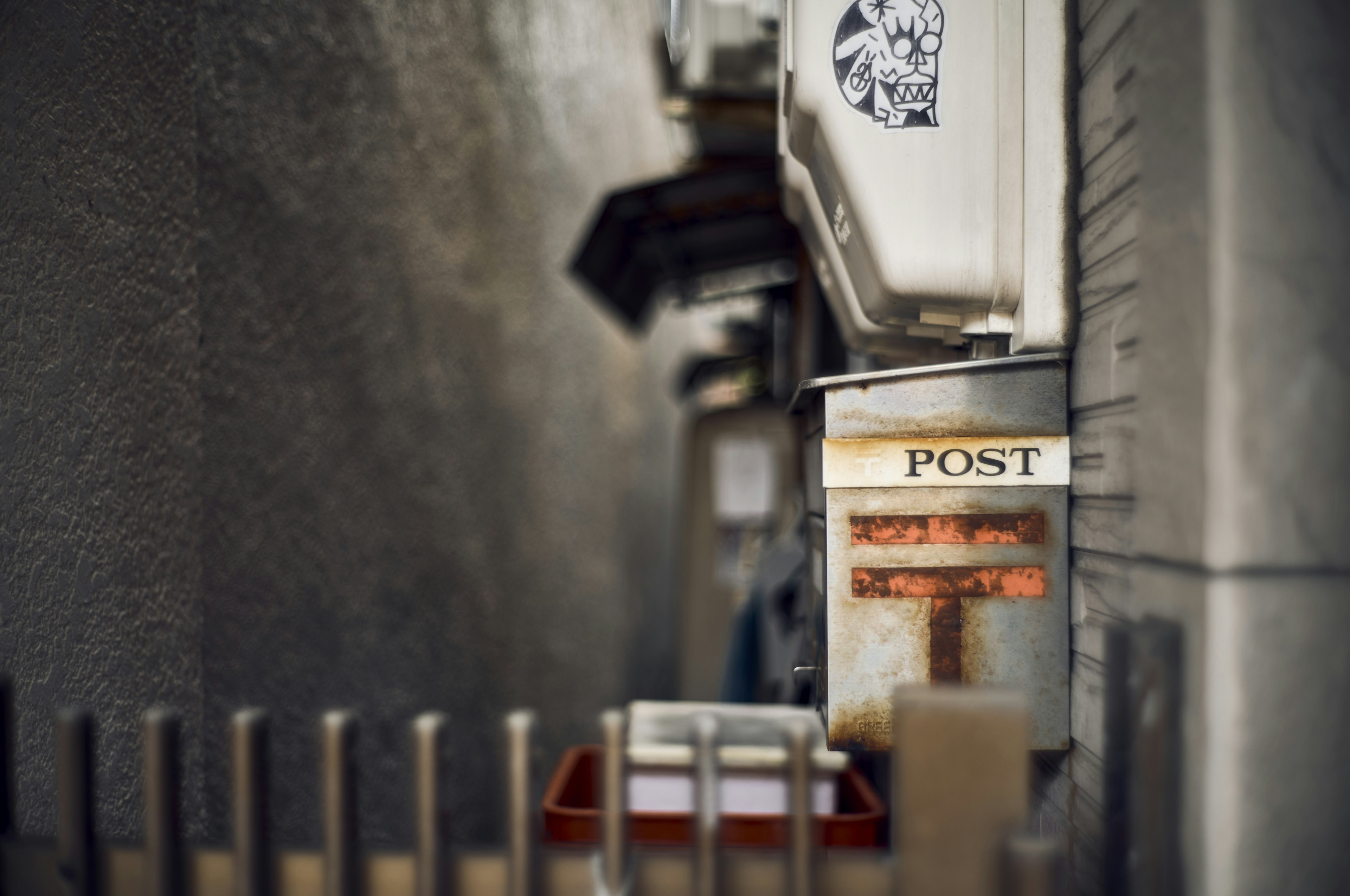 Enge Gasse mit einem alten Postkasten und umliegenden Wänden