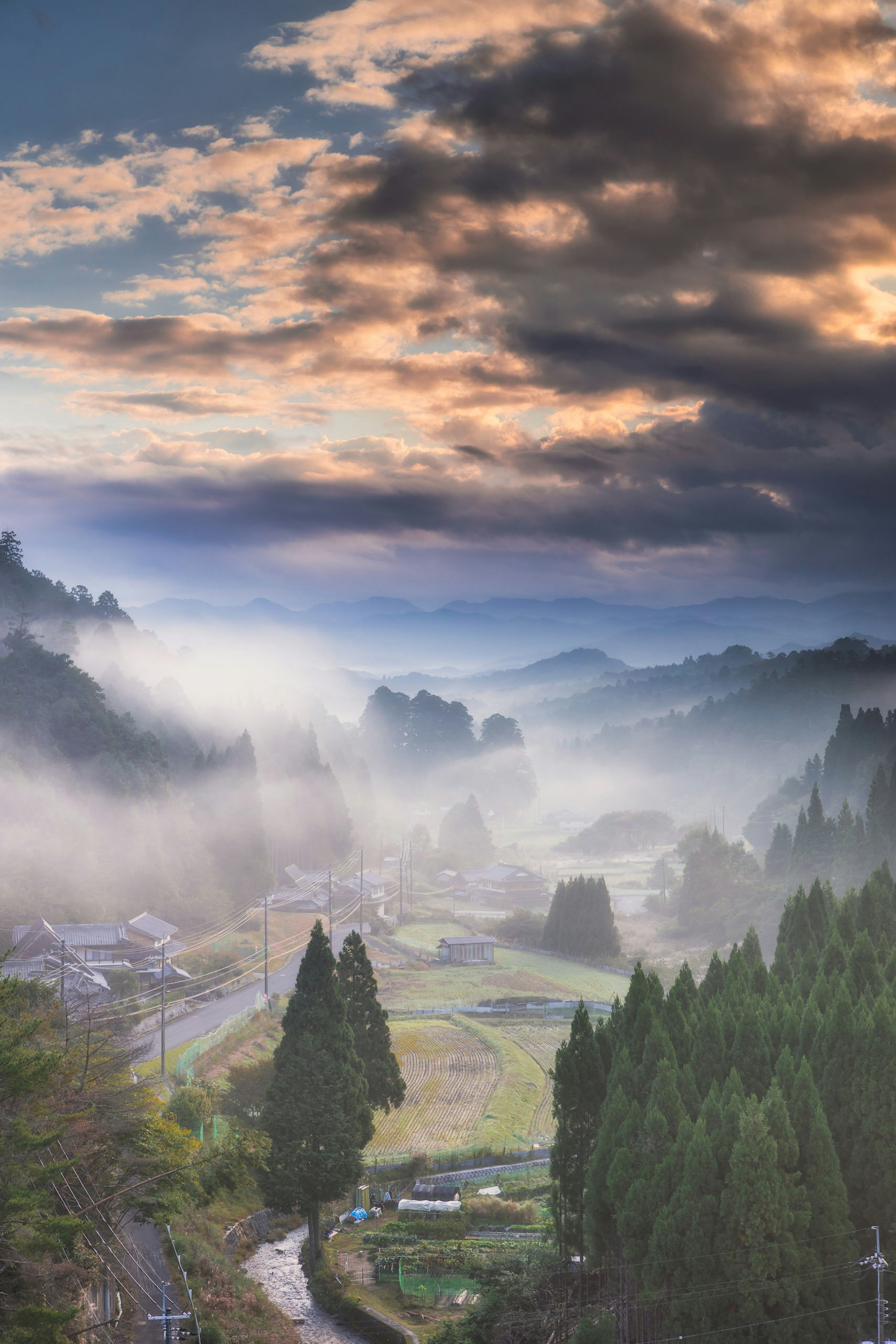 霧に包まれた山間の風景と美しい空の色合い