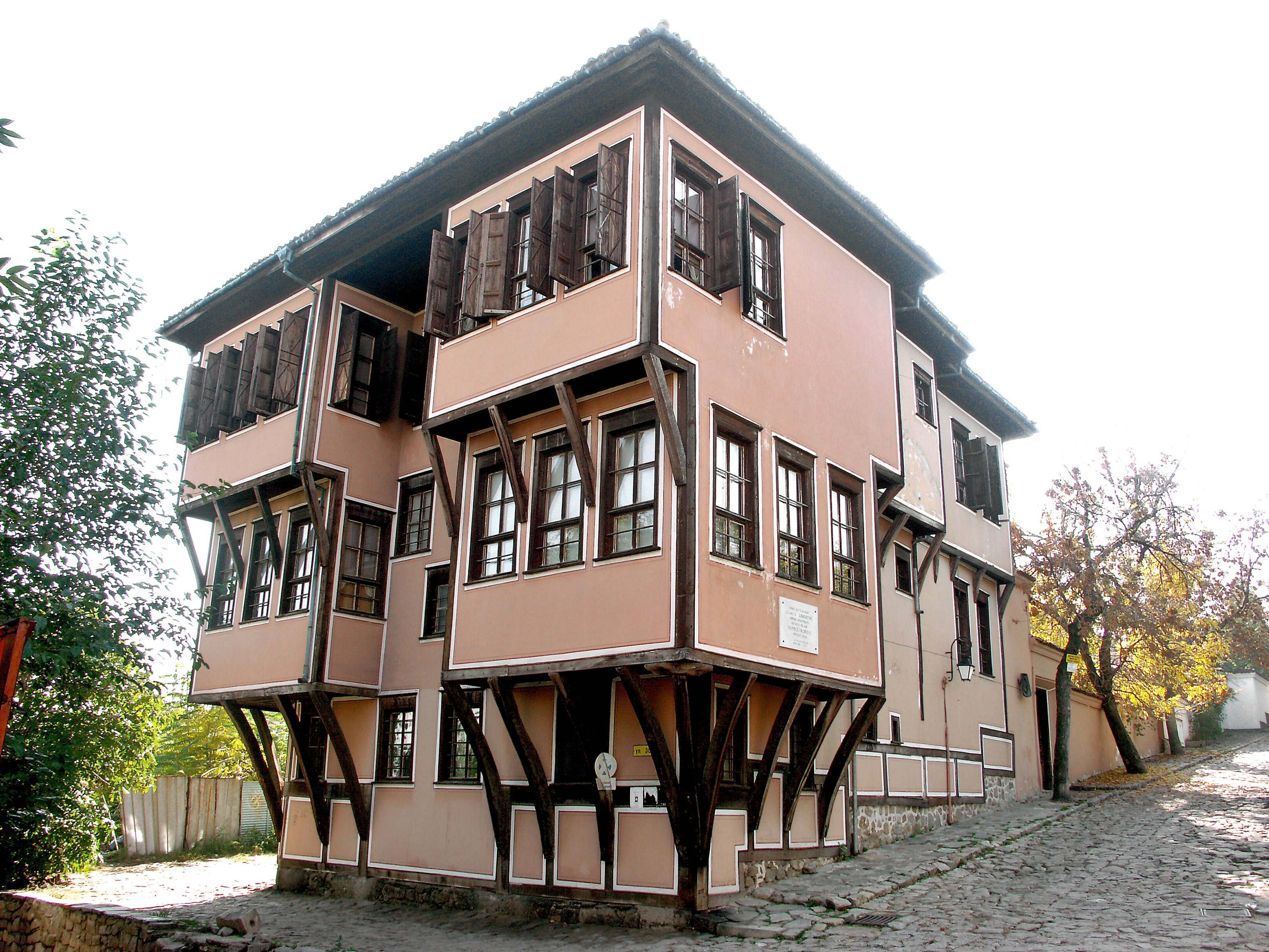 Außenansicht eines historischen Holzhauses mit rosa Struktur