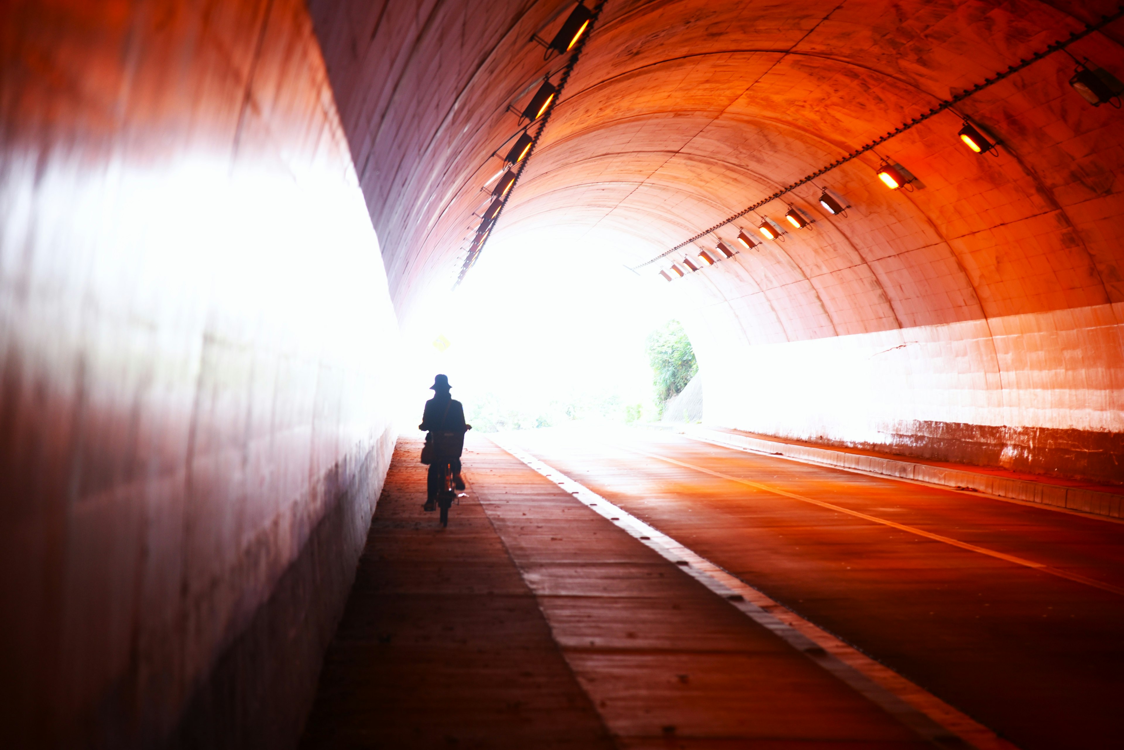 Persona in bicicletta in un tunnel verso una luce brillante