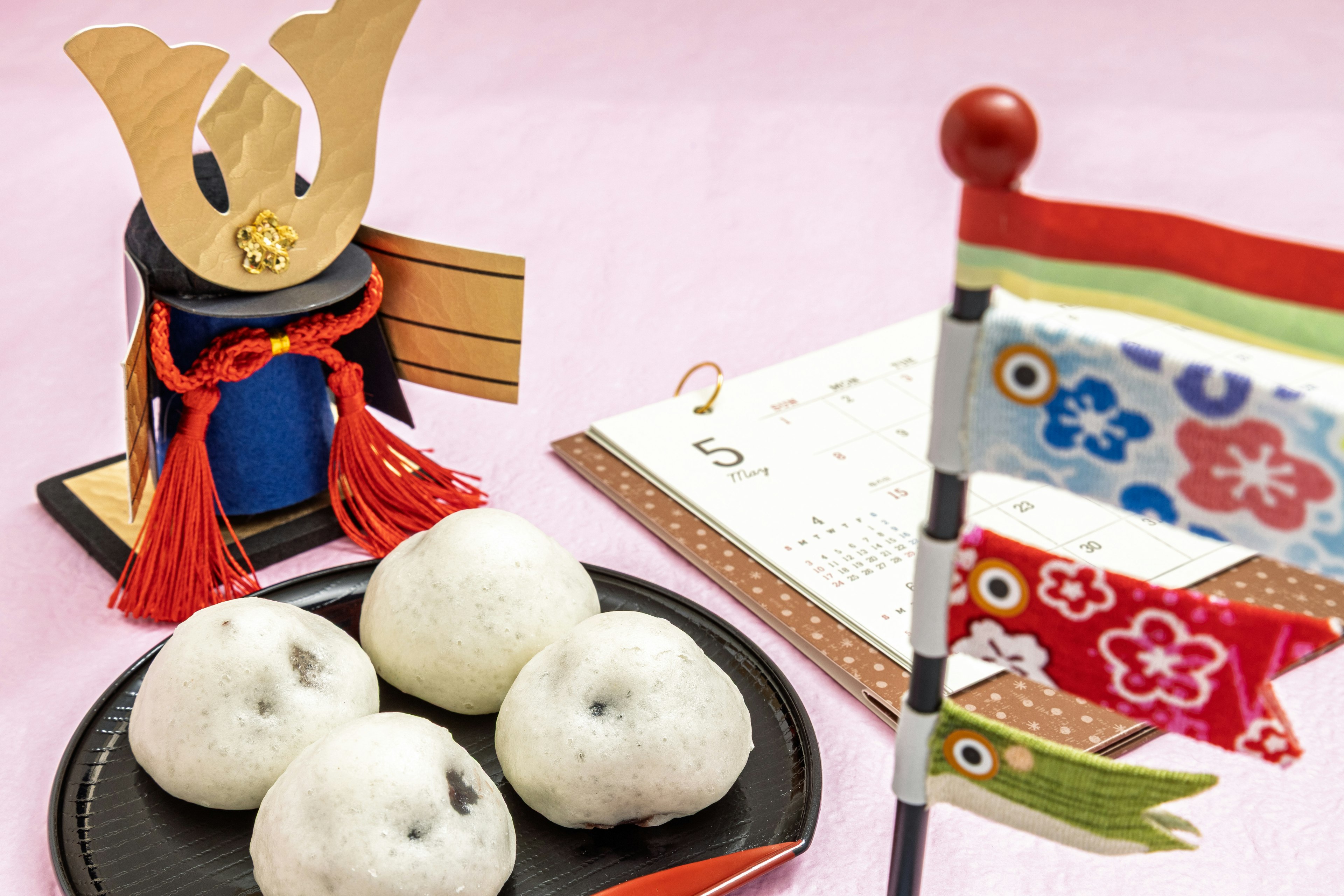 Una exhibición de dulces japoneses tradicionales con un koi nobori y una decoración de casco de samurái