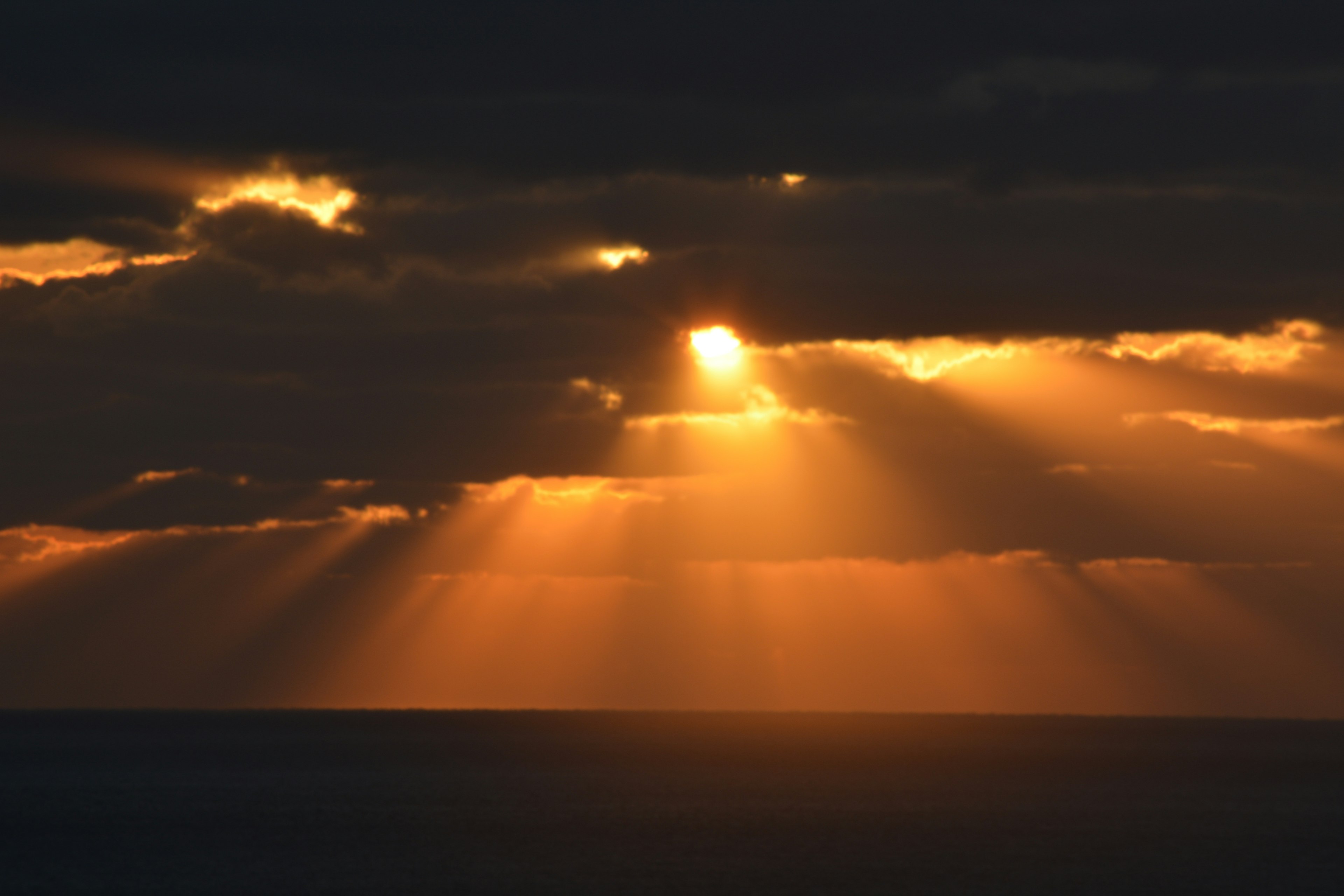 海と雲に差し込む夕日の光