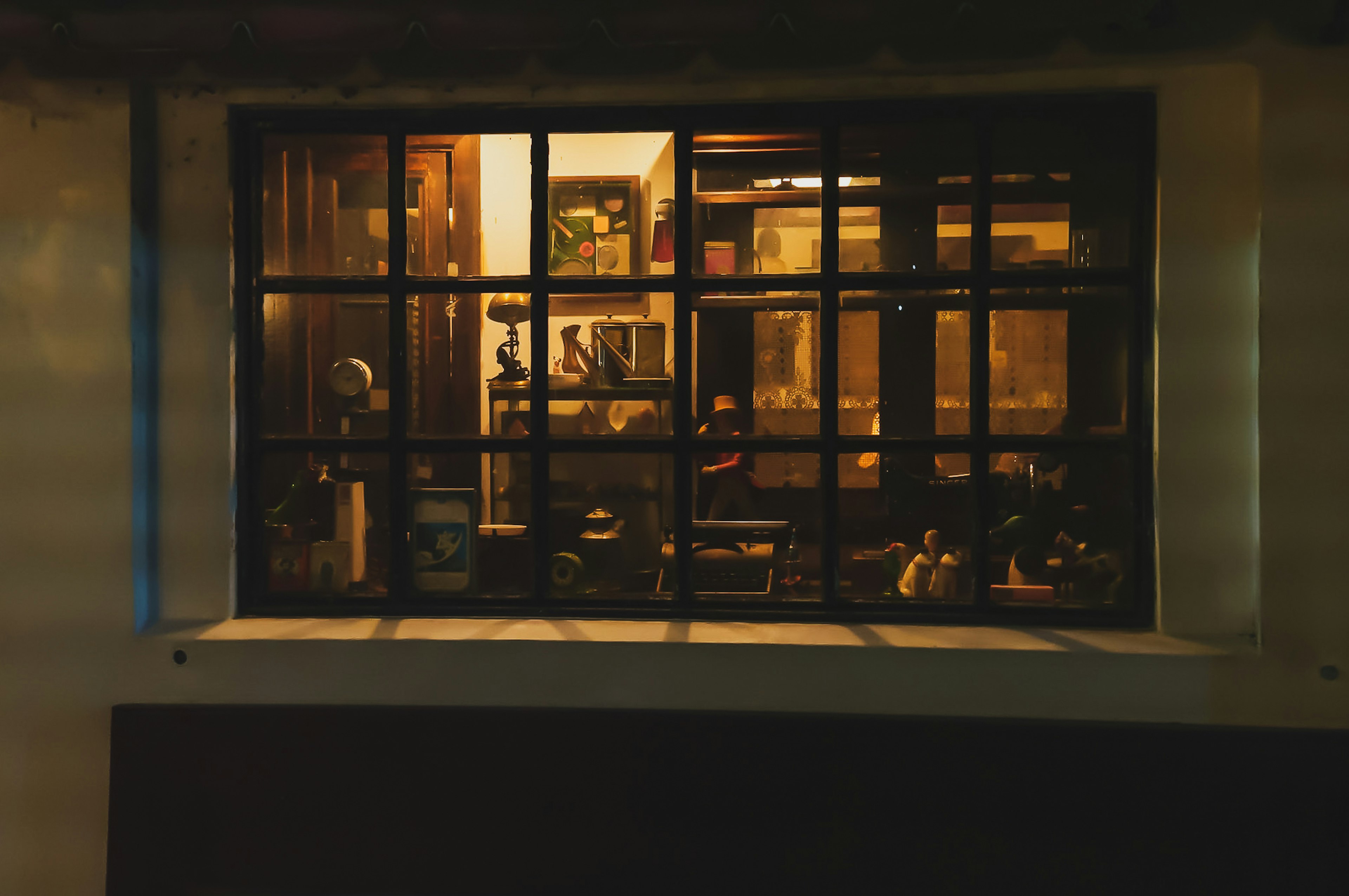 View of a warmly lit vintage shop interior through a window