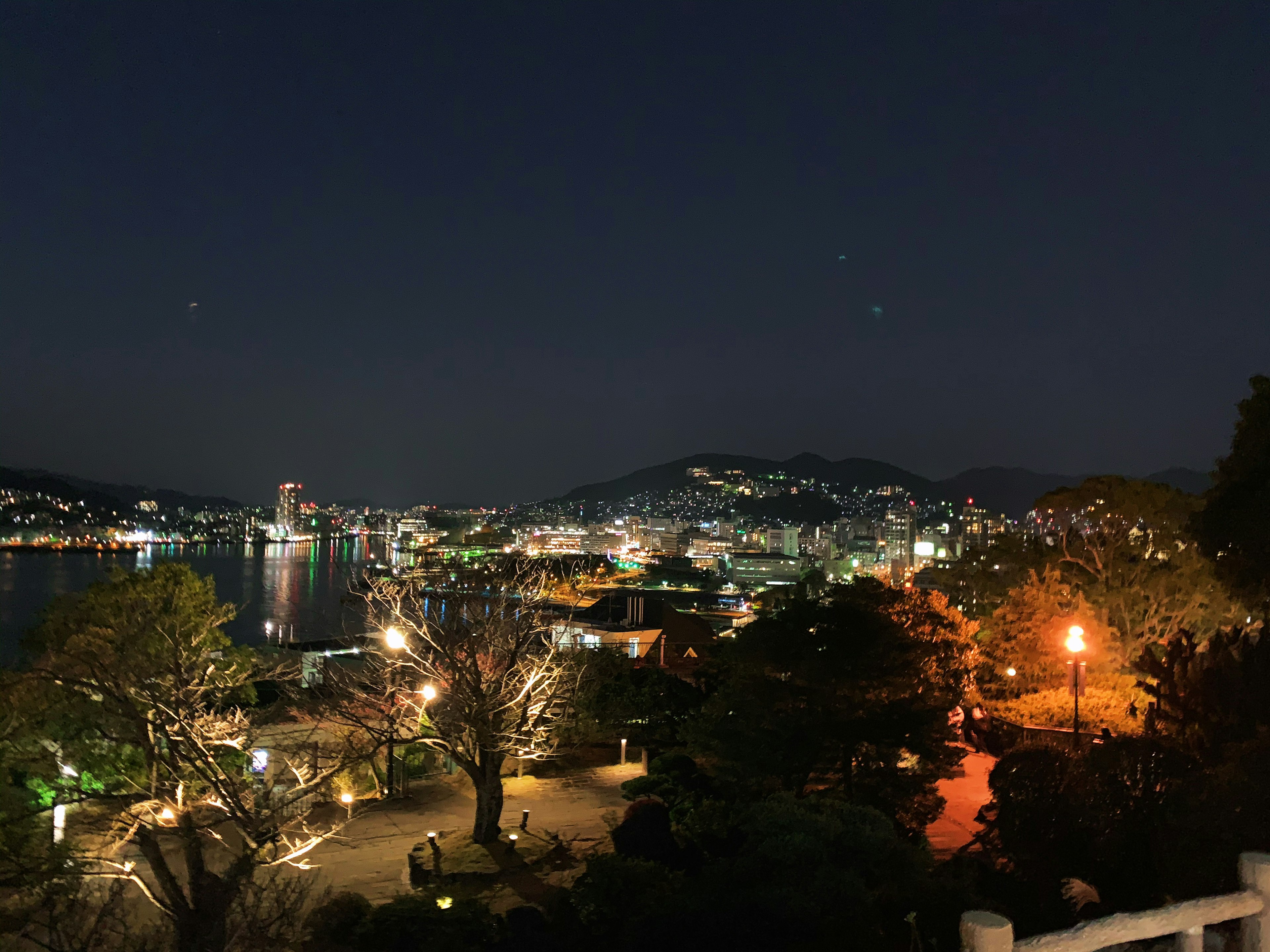 夜景の美しい港町の風景、明るい街灯と海の反射が印象的