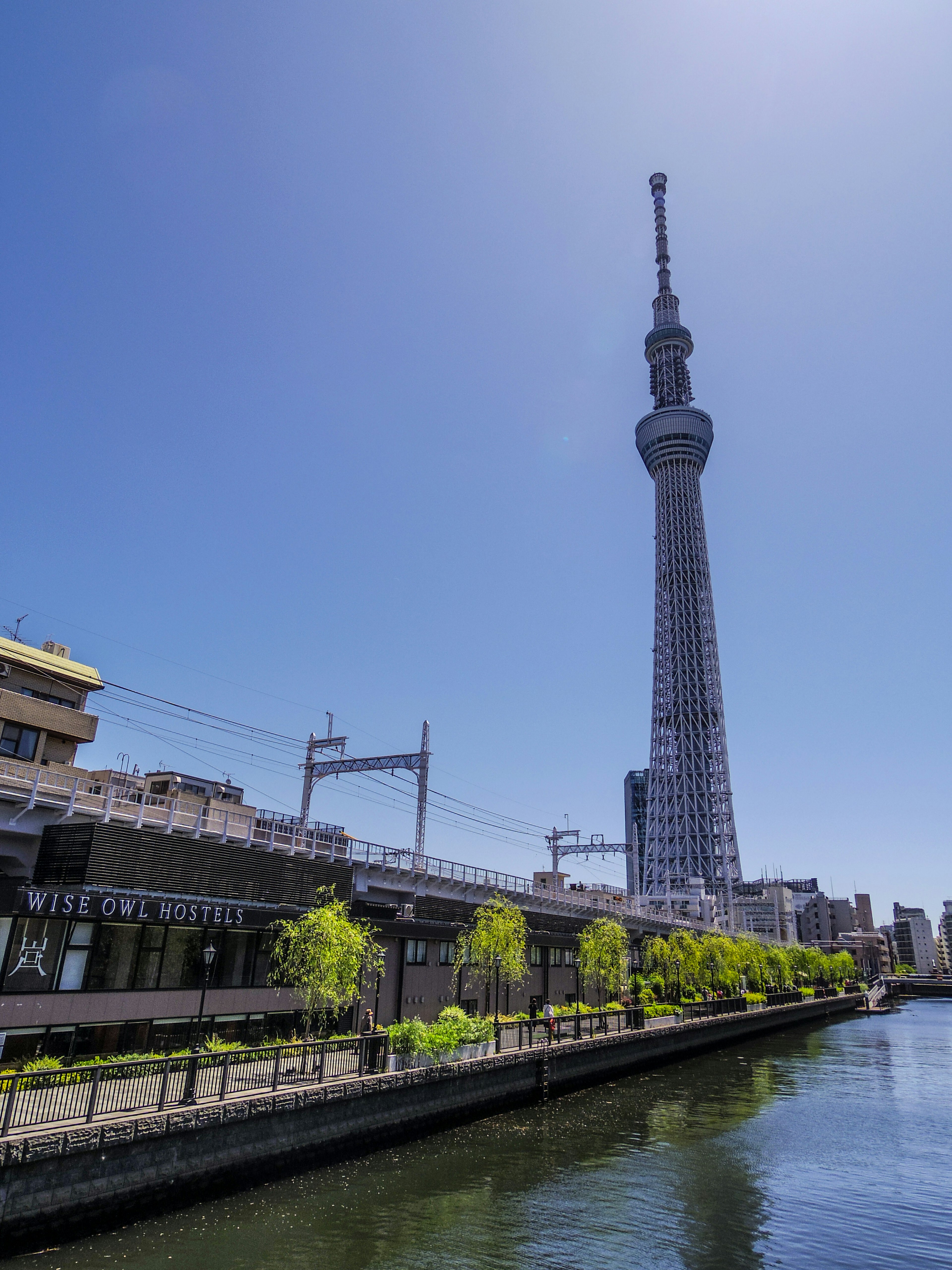 Tokyo Skytree che svetta sul fiume con cielo blu chiaro