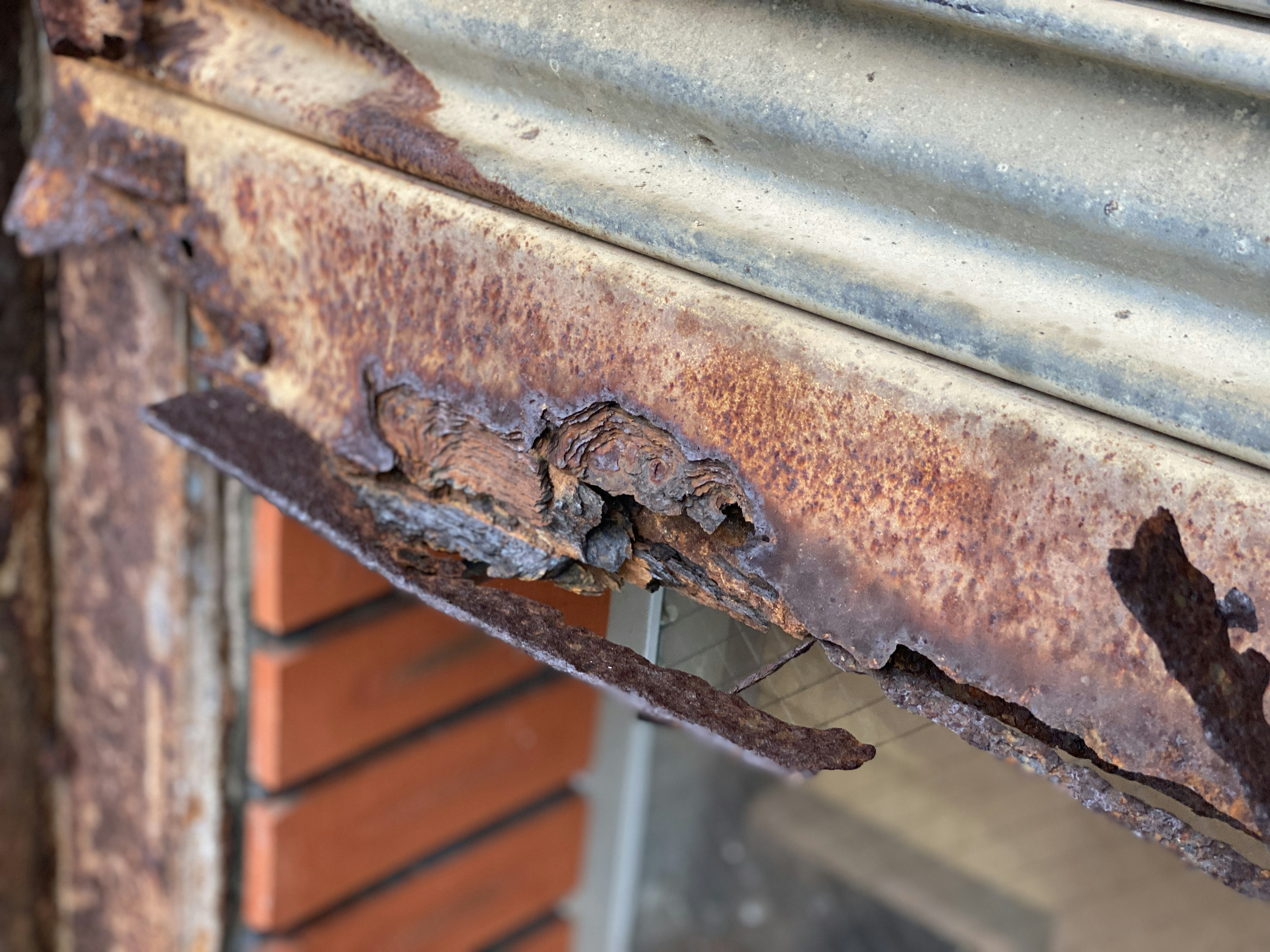 Nahaufnahme eines rostigen Metallrahmens mit abblätternder Farbe