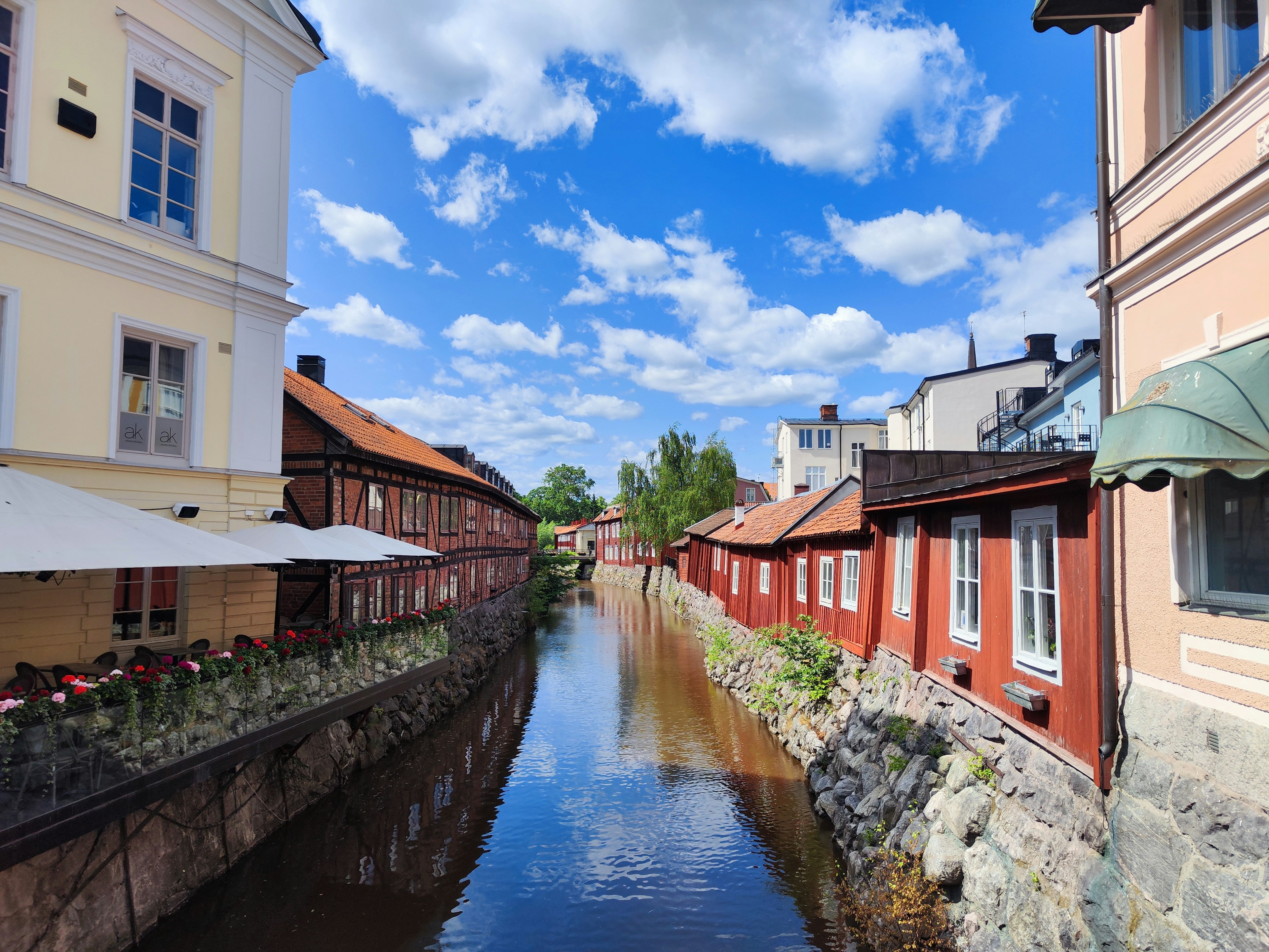 Scenic canal view with red houses and bright blue sky