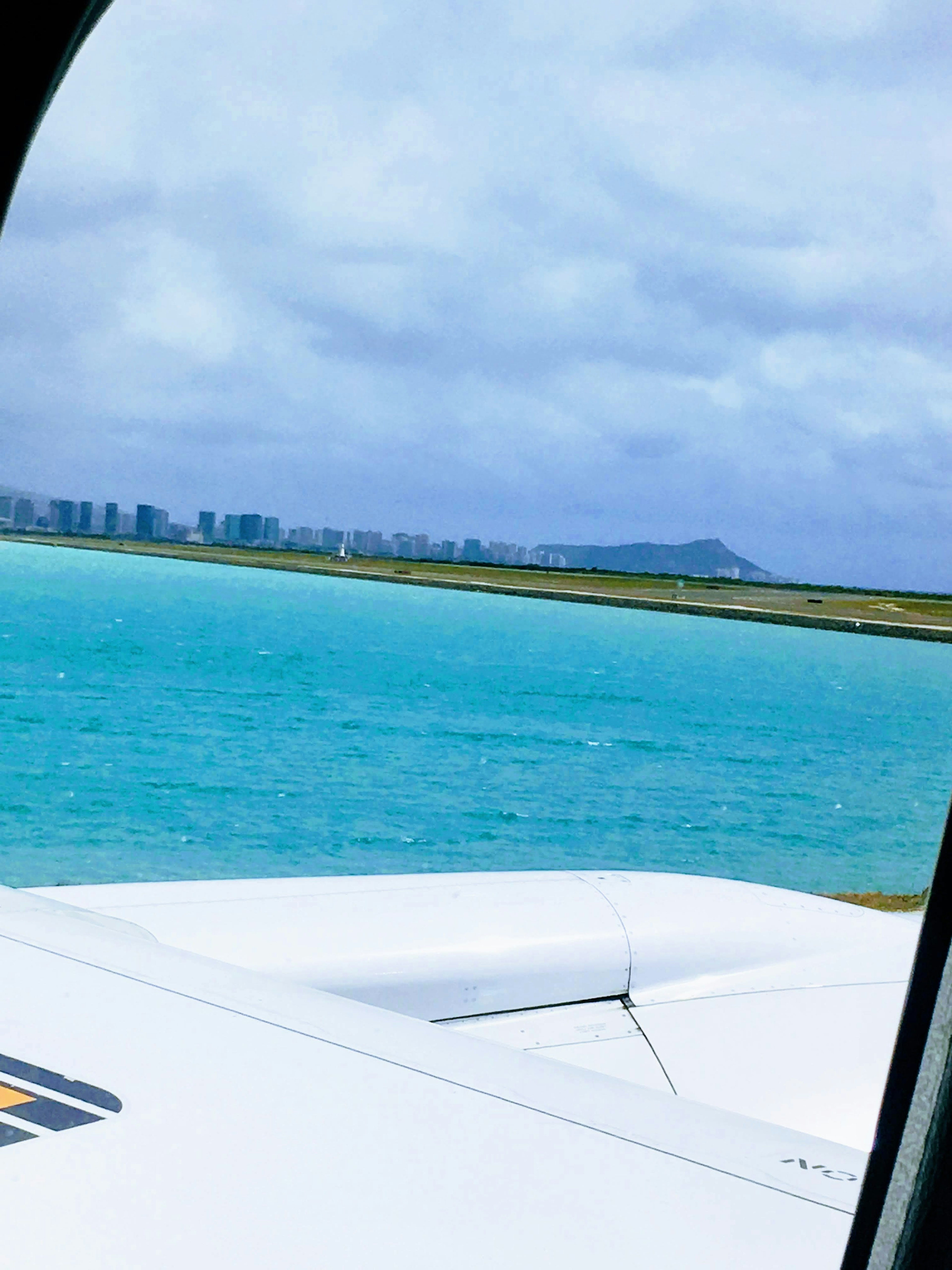 Vista aérea de agua turquesa y el horizonte de la ciudad cerca del aeropuerto