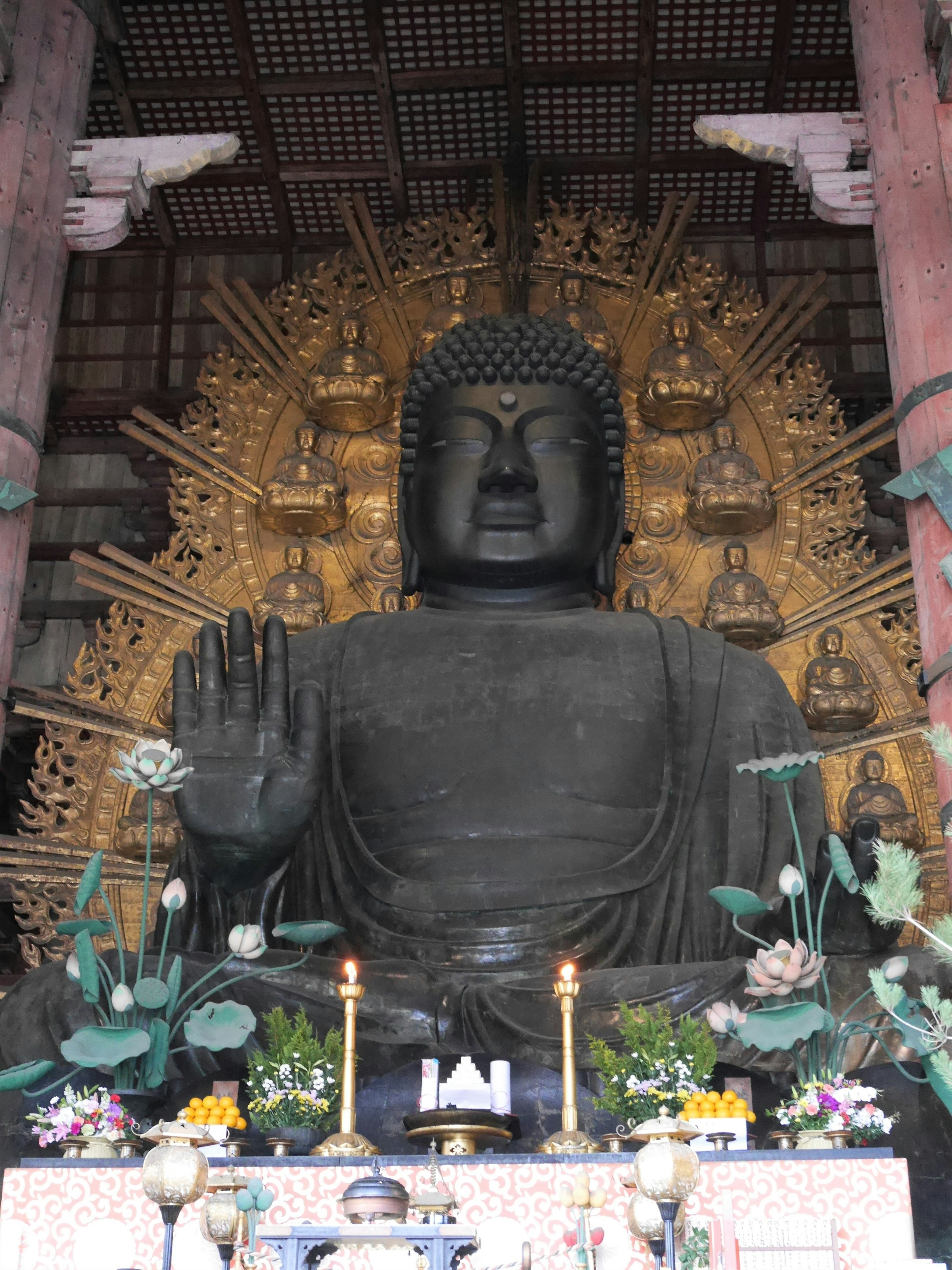 Patung Buddha besar dengan halo emas di latar belakang