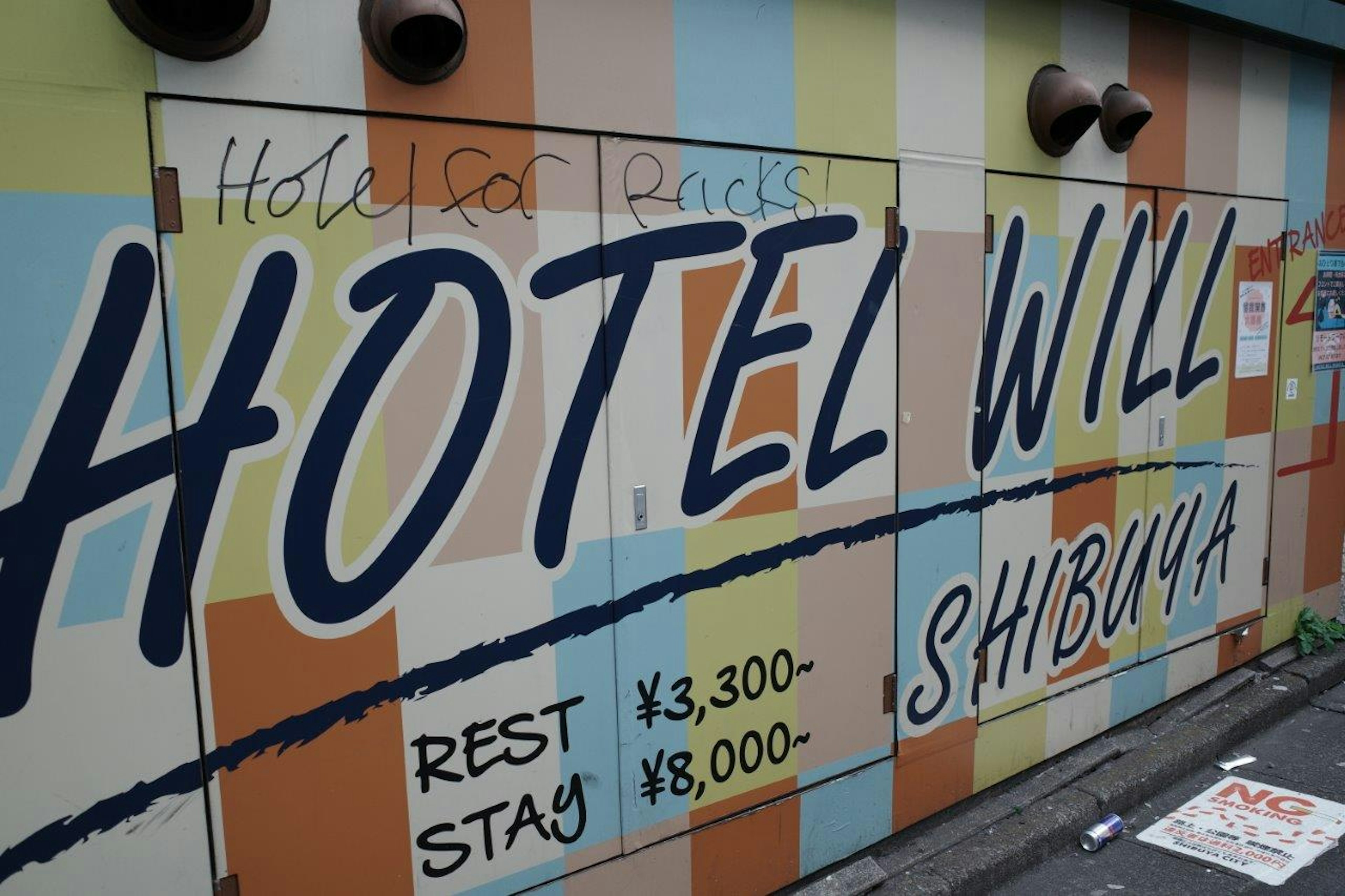 Colorful exterior wall of Hotel Will in Shibuya with pricing information