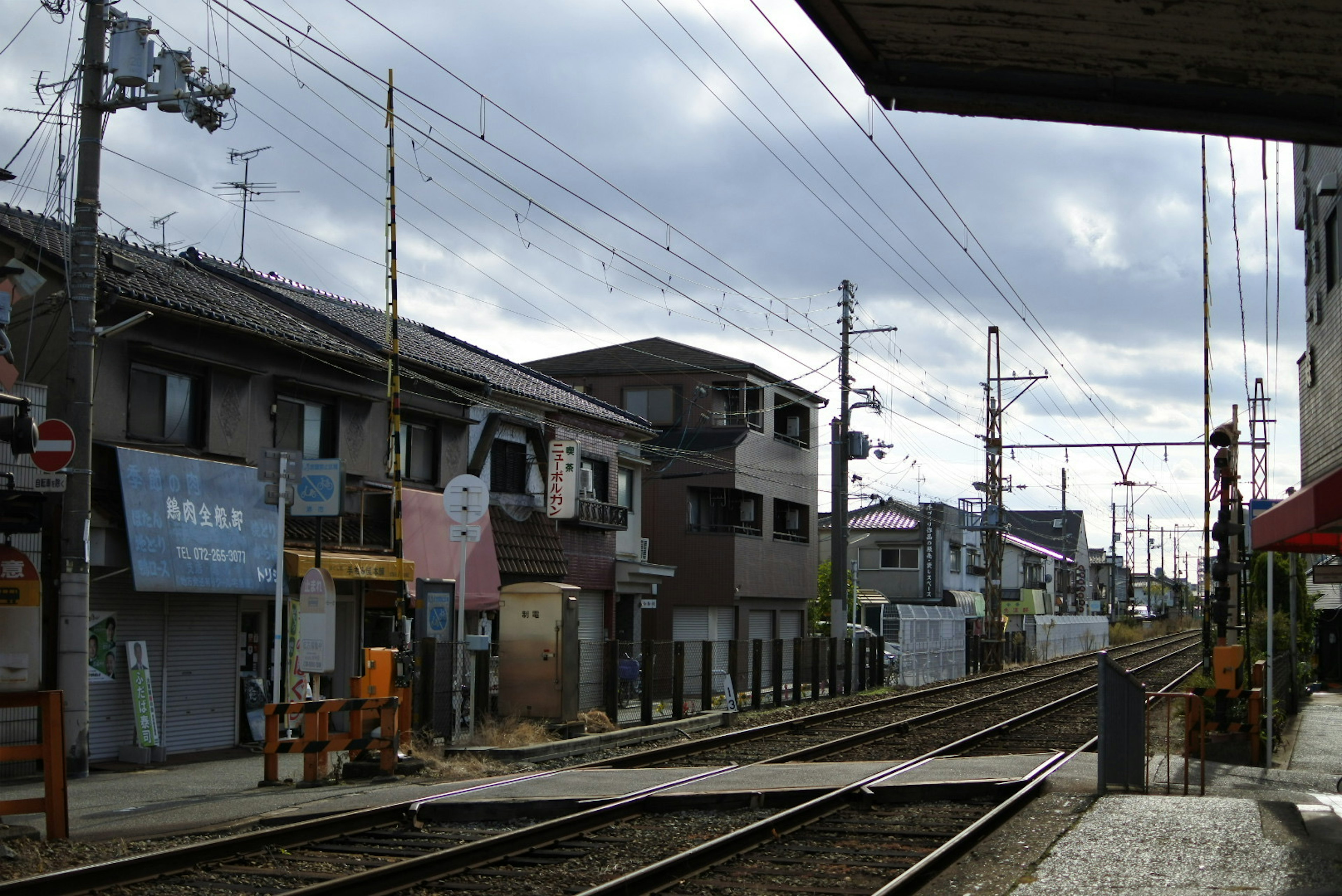 Quiet train station scene with old buildings and railway tracks