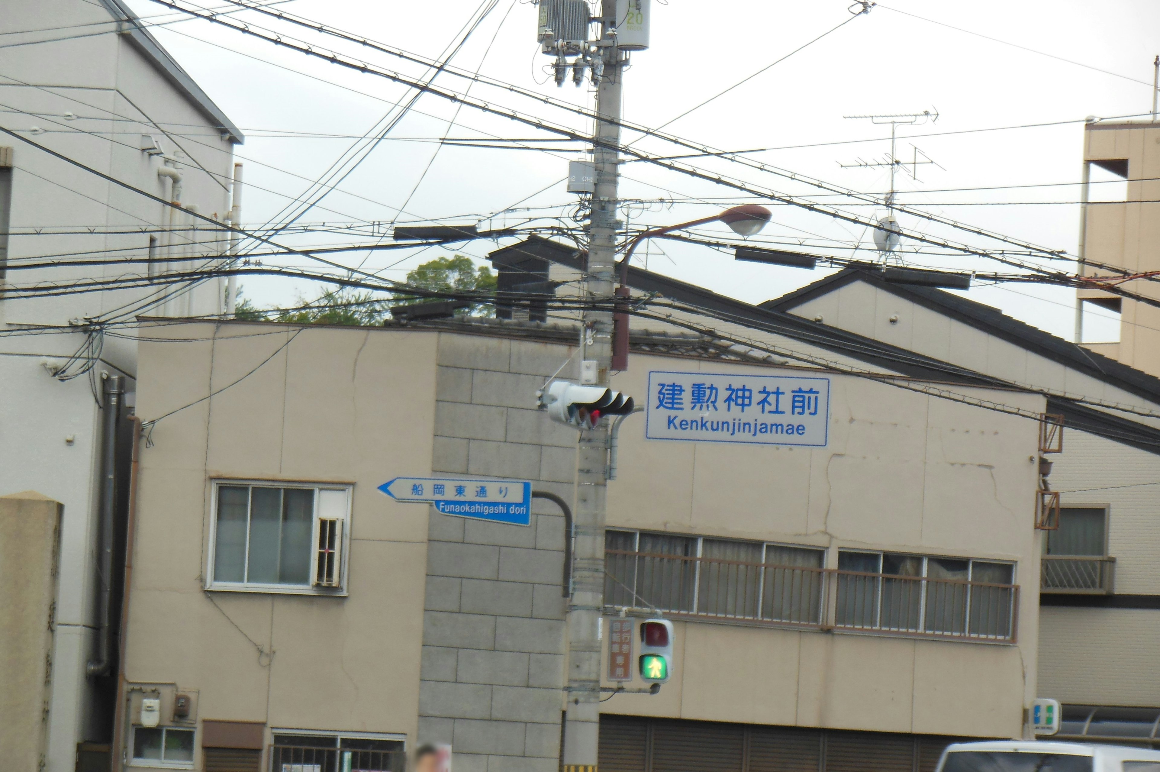 Scena urbana con facciata di edificio e linee elettriche incrociate