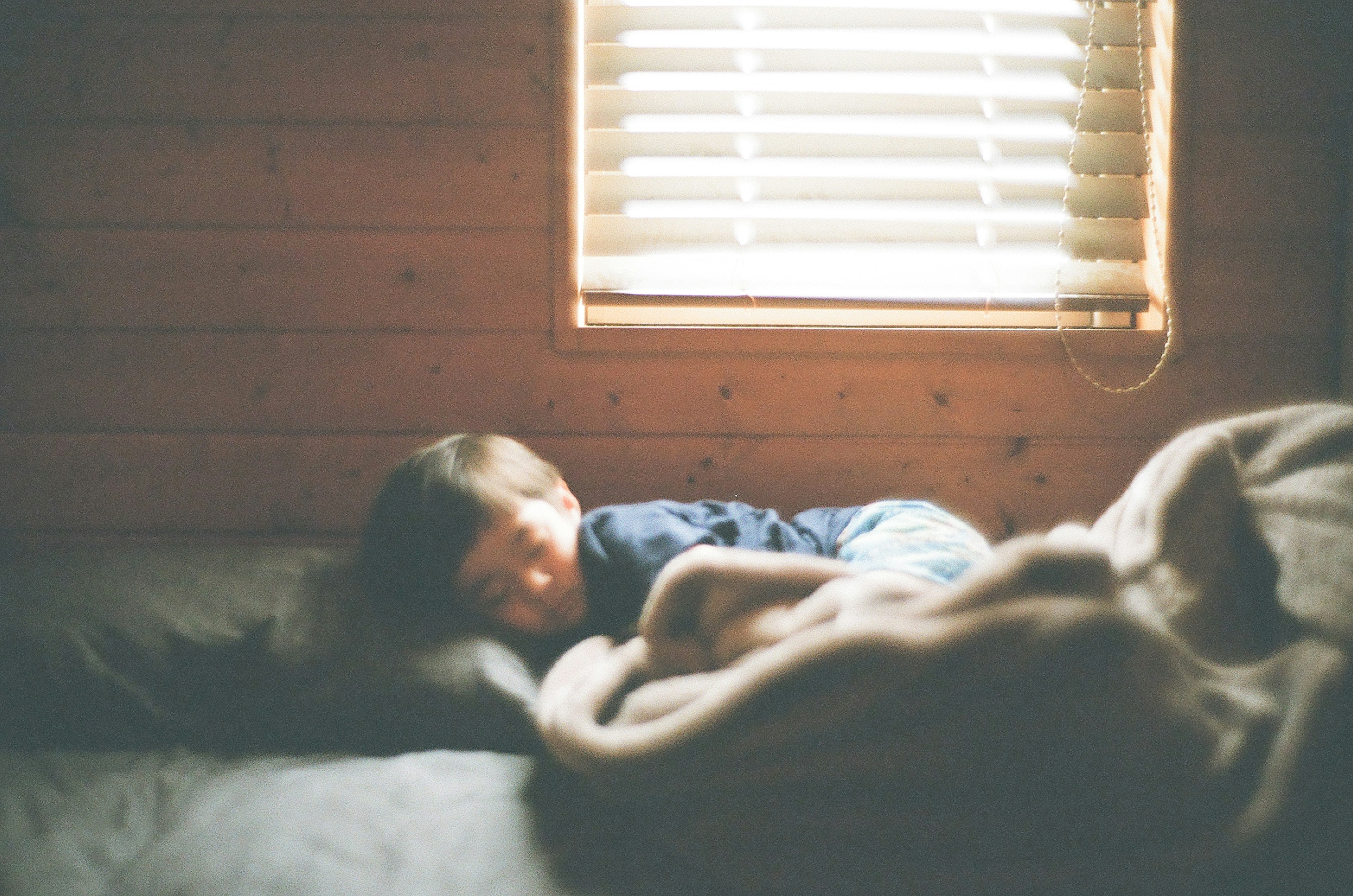 Child sleeping peacefully in a cozy room with soft light from the window