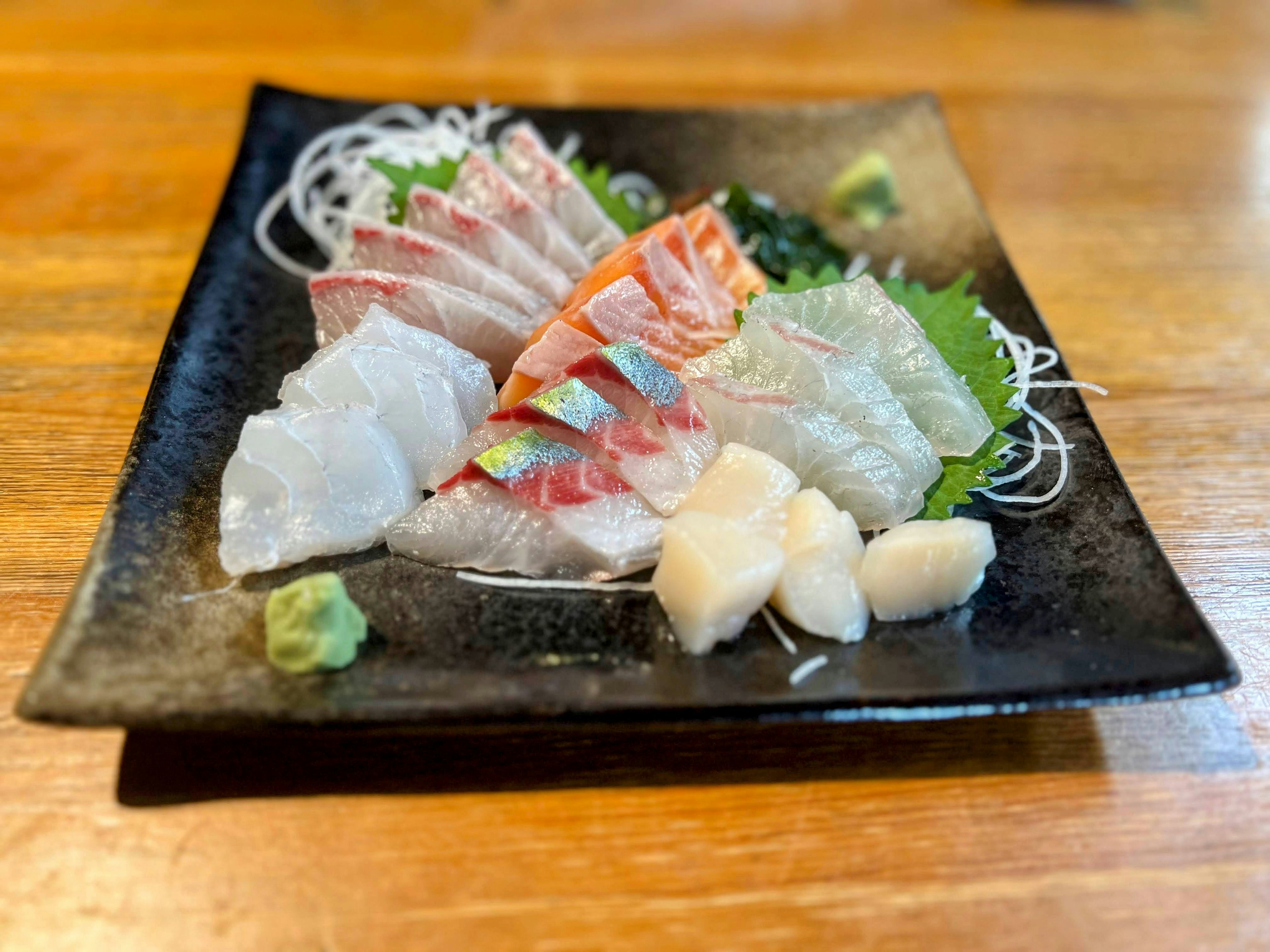 Fresh sashimi platter served on a black plate