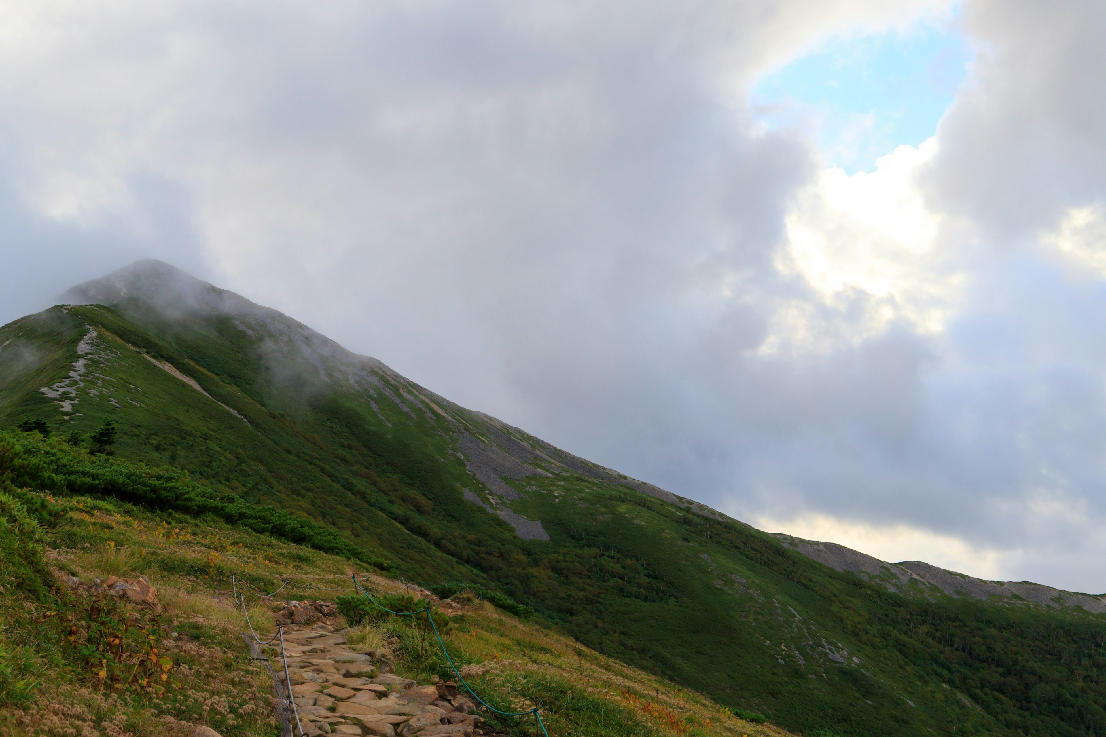 Vista panoramica di una montagna verde con nuvole