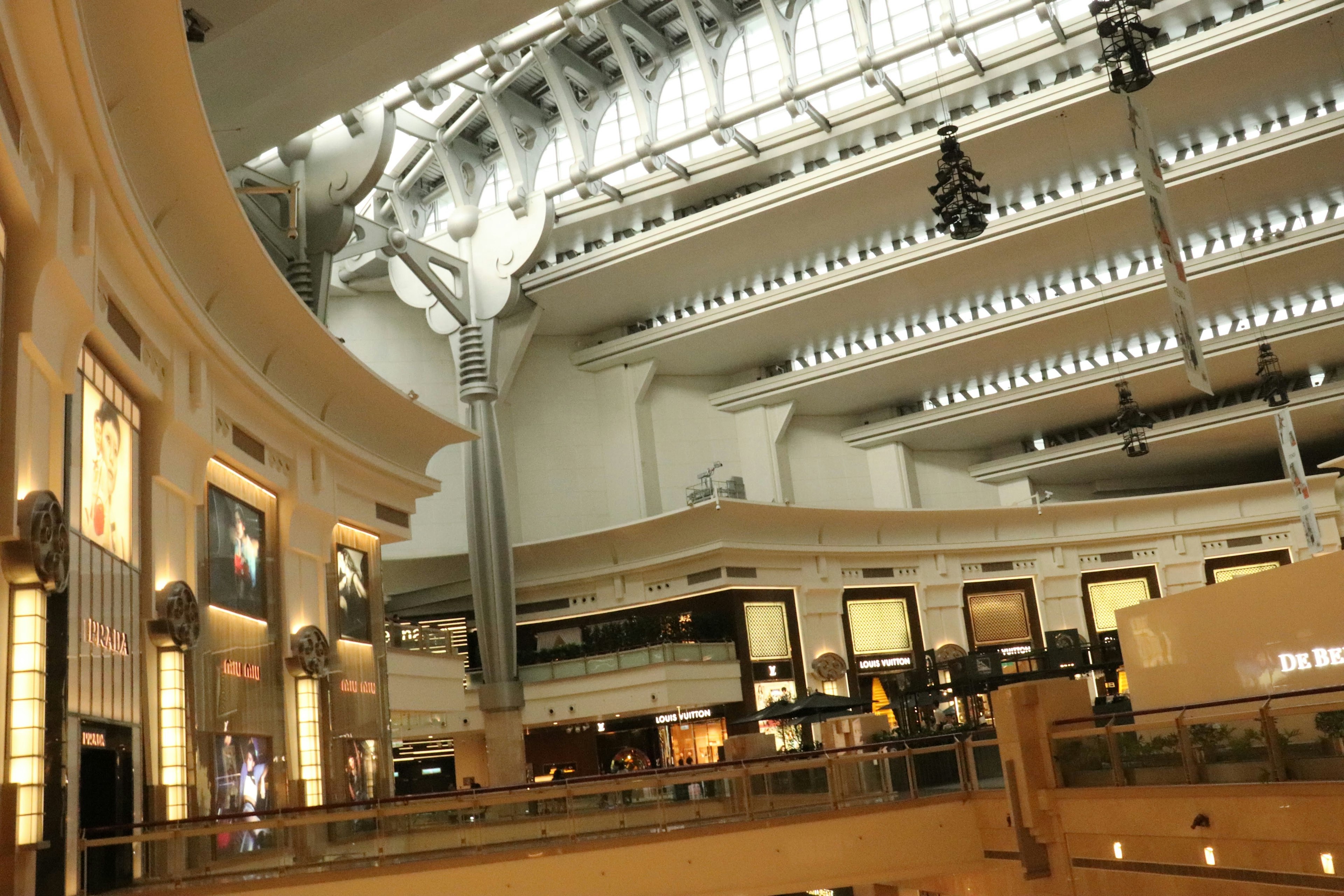 Spacious shopping mall interior Bright lighting and modern design High ceiling and elegant stores