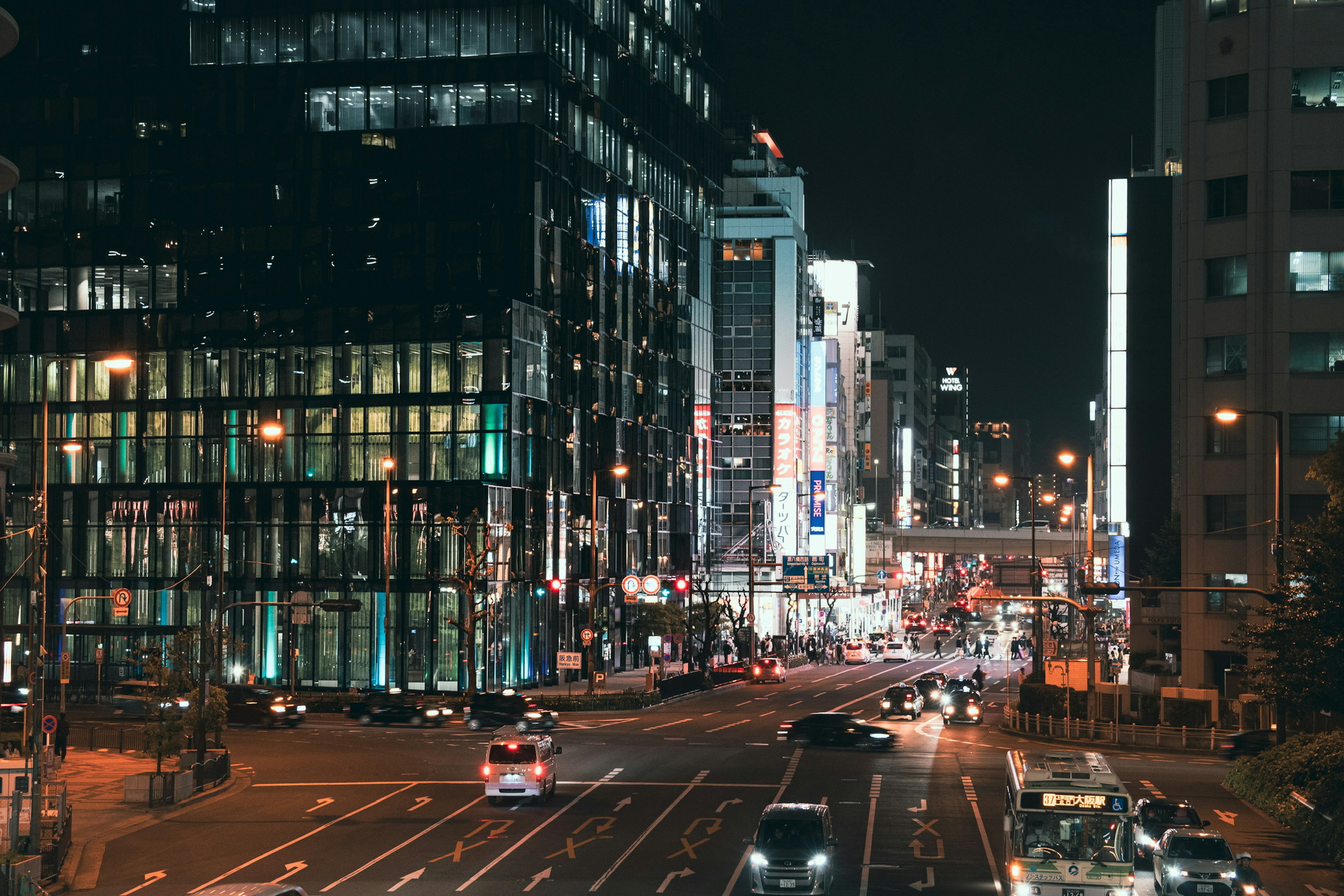 Paesaggio urbano notturno con traffico vivace e insegne luminose