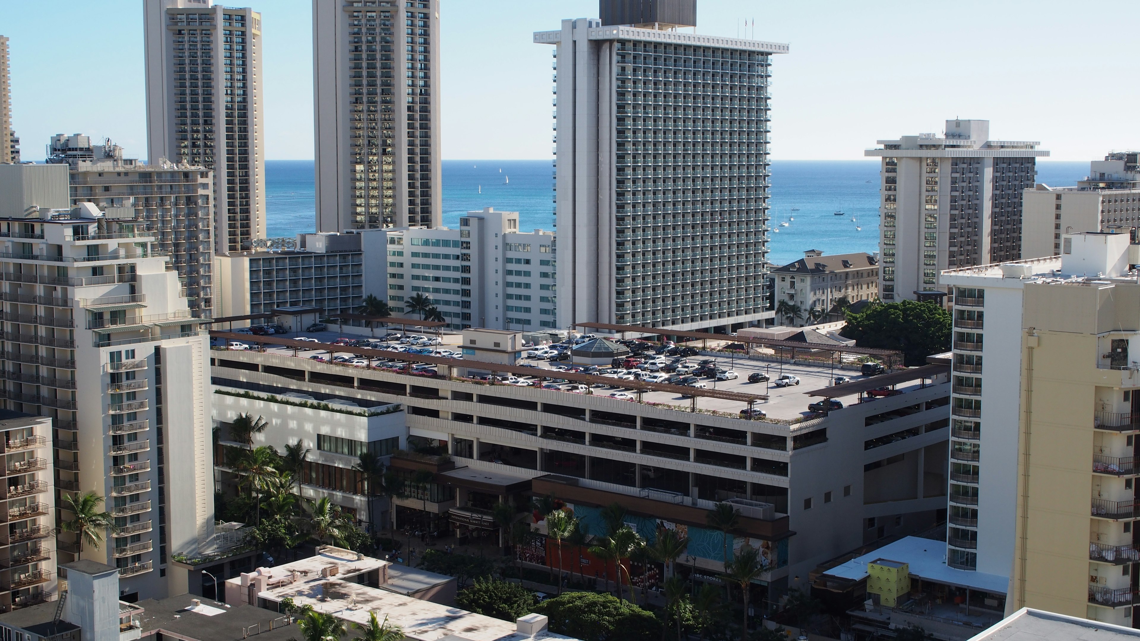 Vista de edificios altos con vista al océano y un estacionamiento