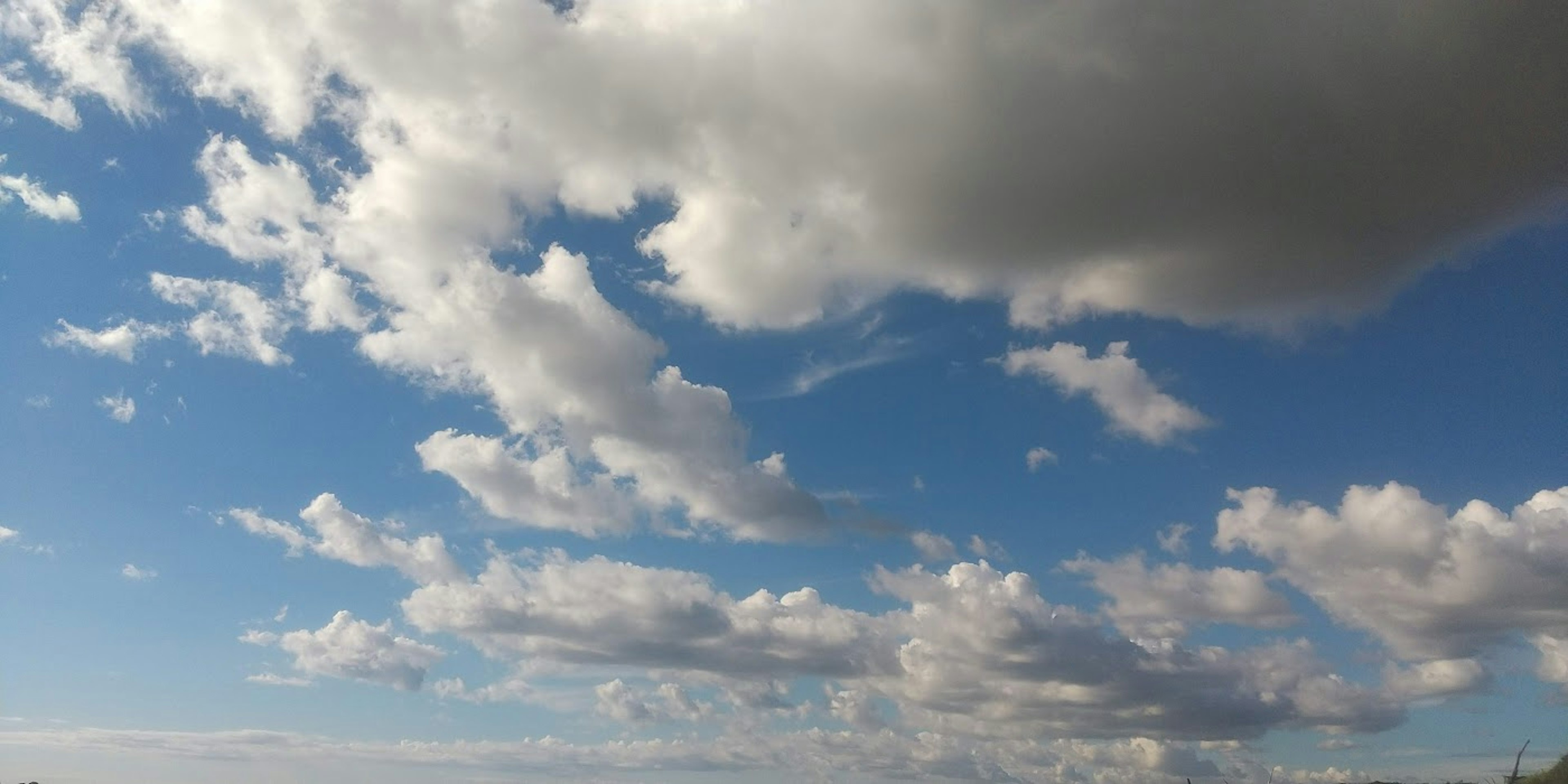 Un paysage avec un ciel bleu et des nuages blancs