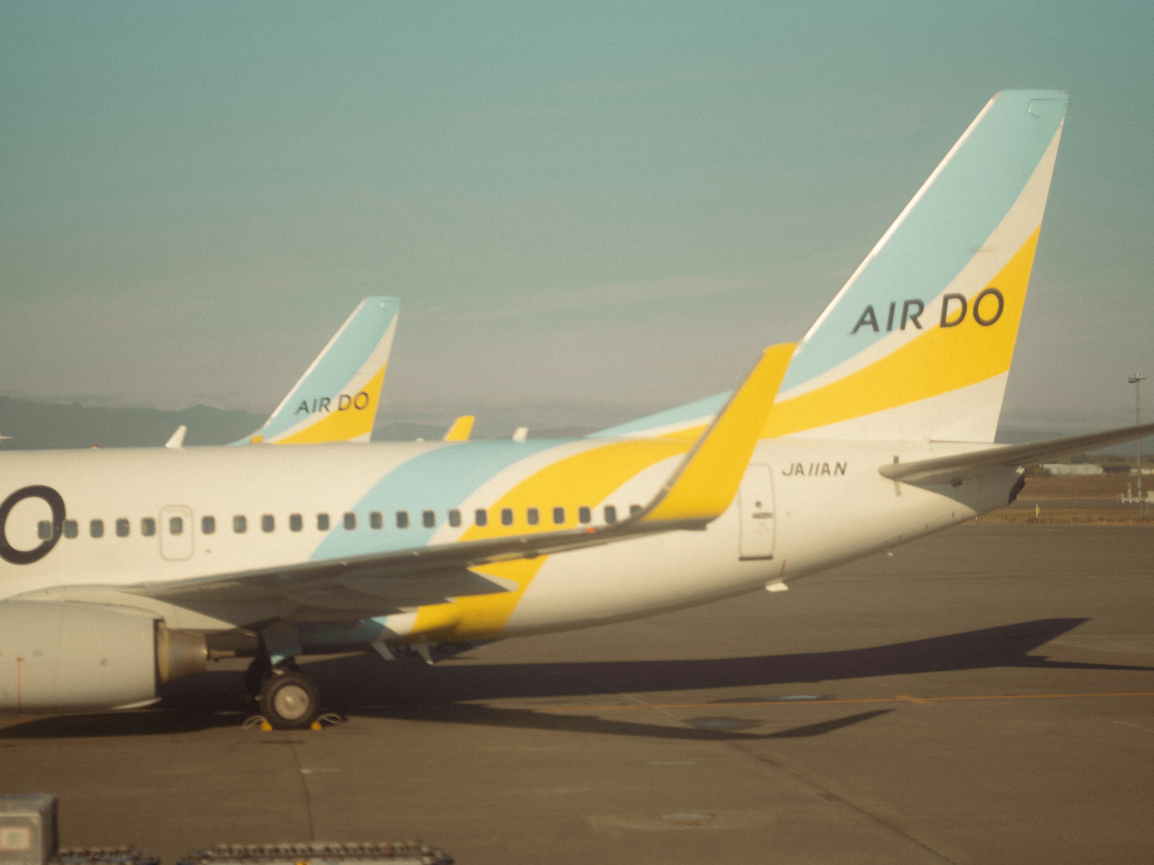 Due code di aerei AIR DO con design blu e giallo distintivi in aeroporto