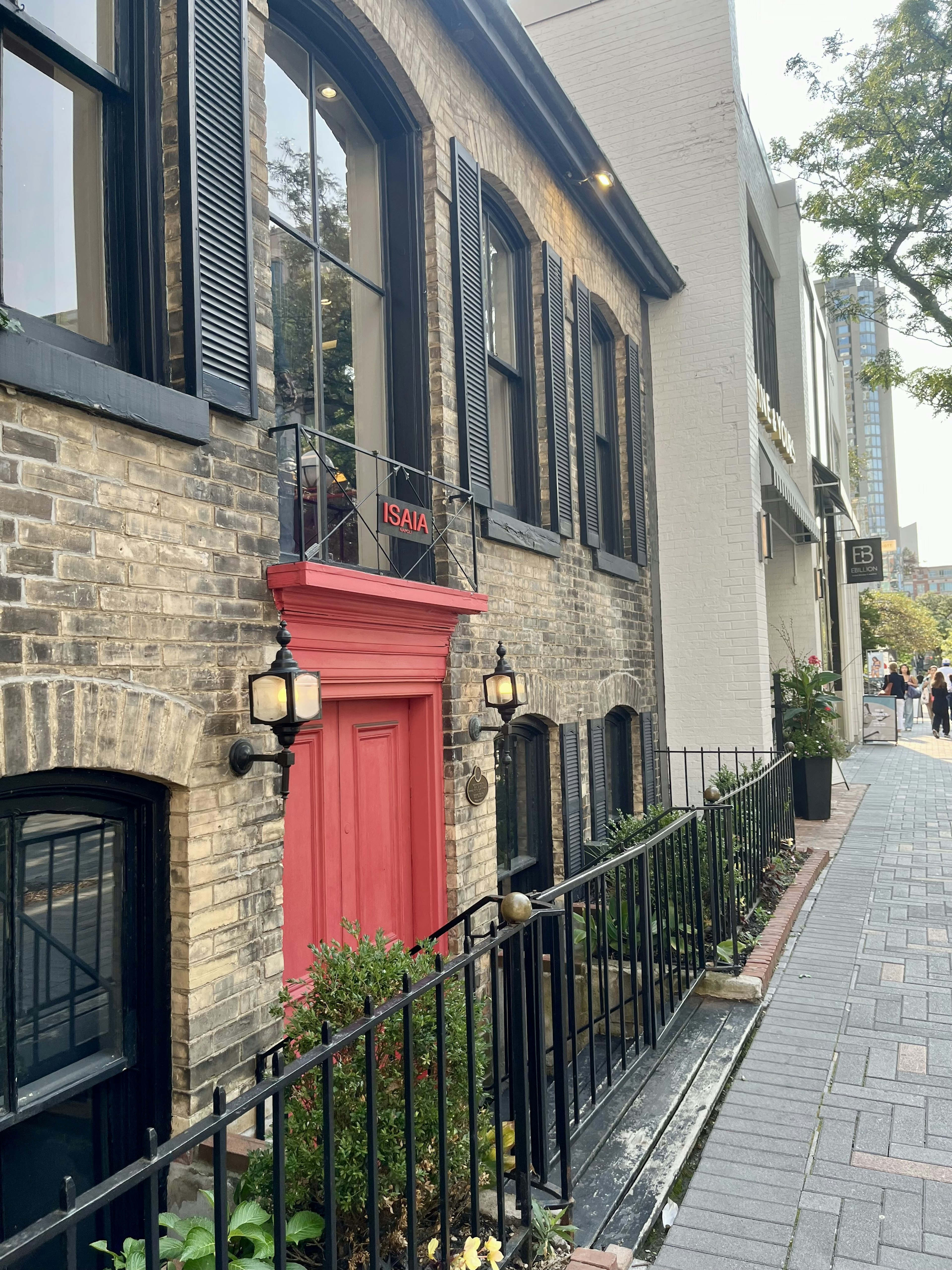 Exterior de un edificio histórico con una puerta roja y paredes de ladrillo