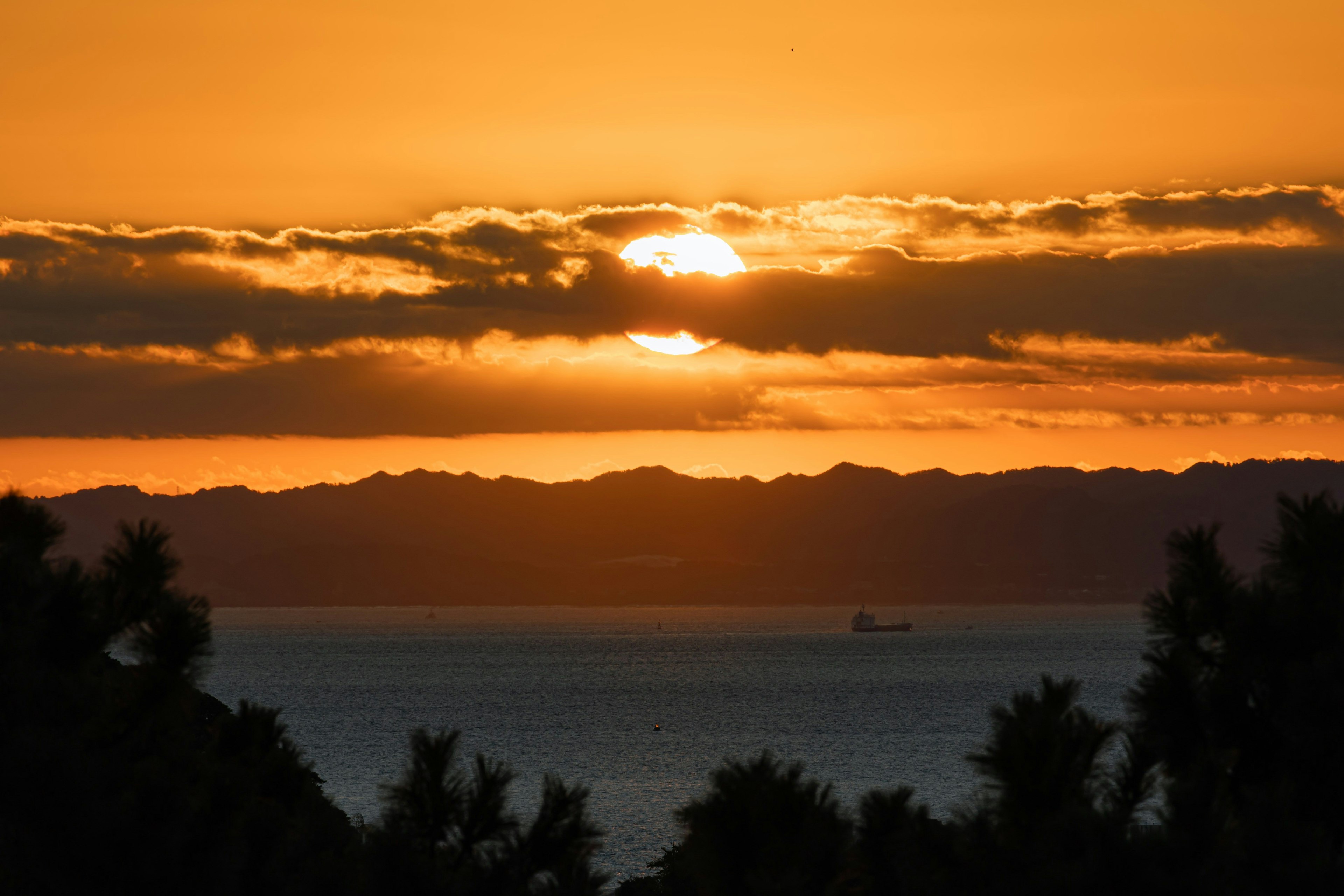 夕日が海に沈む美しい風景 様々なオレンジ色の空と山々
