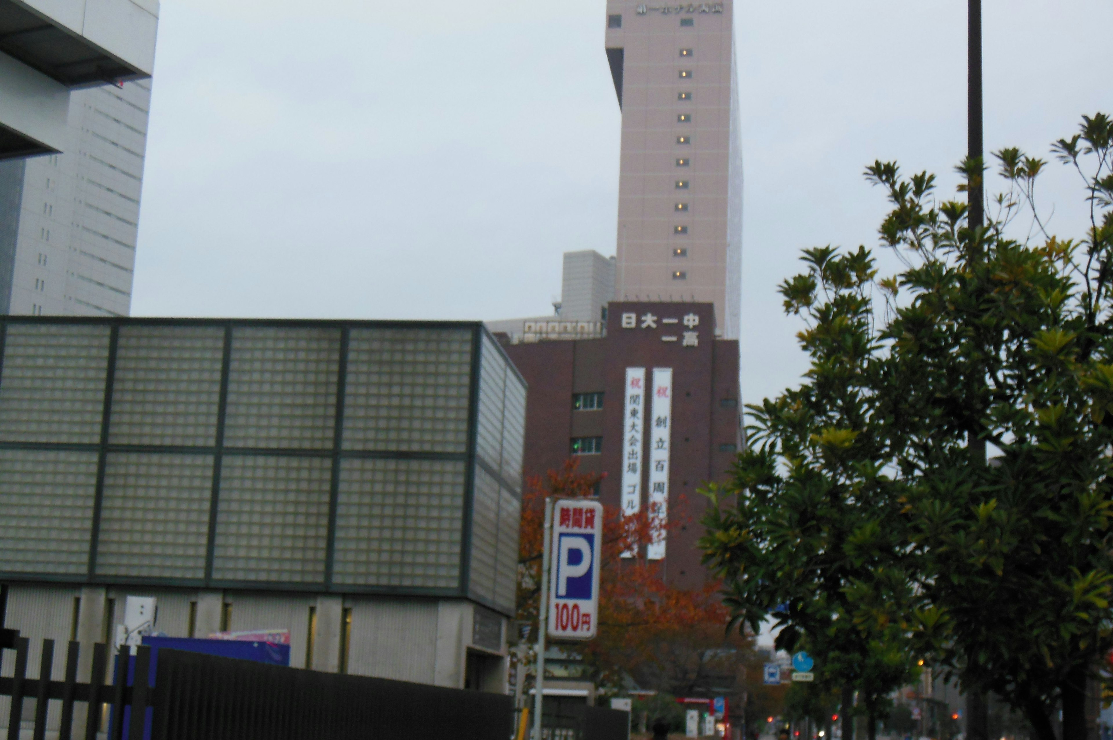 Städtische Szene mit einem hohen Gebäude und einem Parkschild