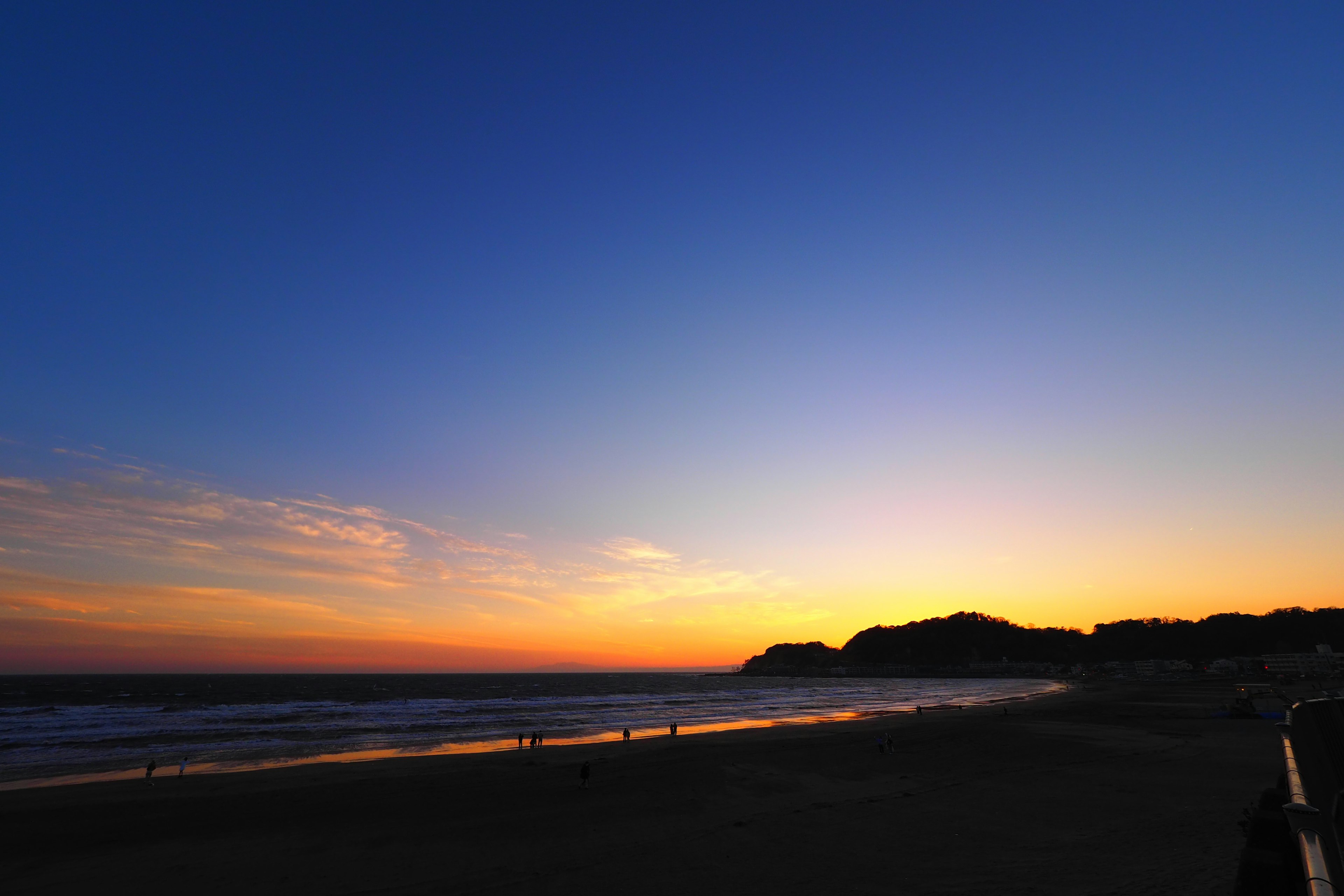 Beeindruckende Küstenansicht bei Sonnenuntergang mit blauem Himmel