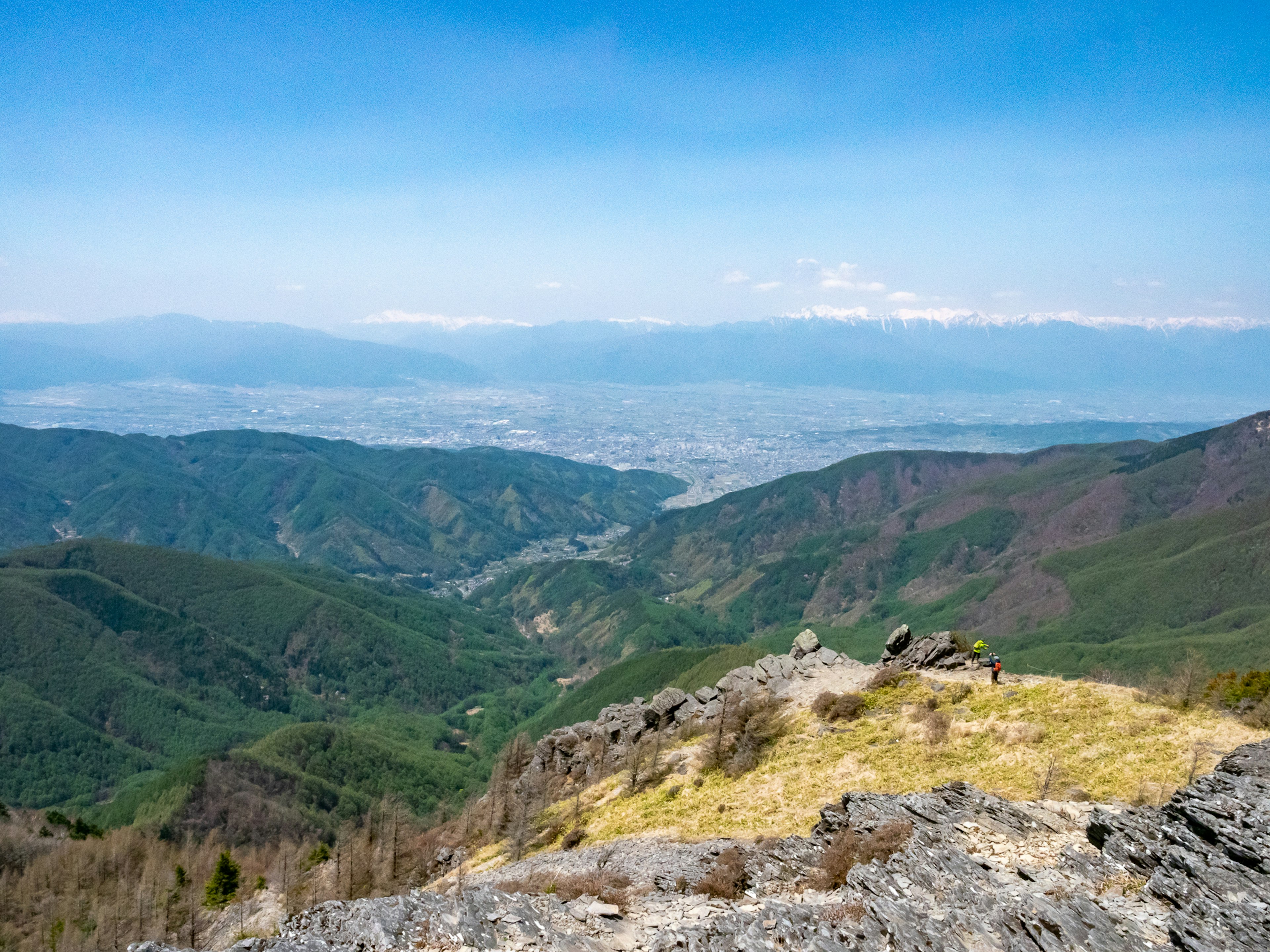 Vista panoramica dalla cima della montagna con colline verdi e una città in lontananza