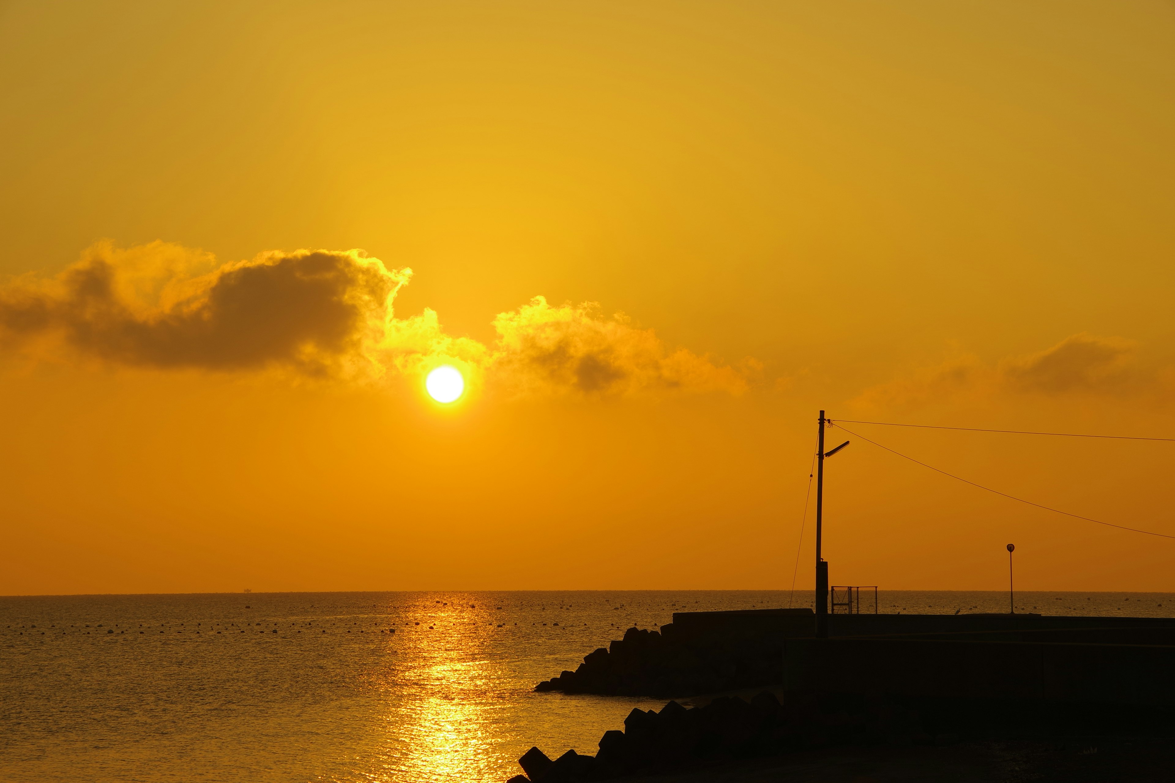 Bellissimo tramonto sul mare con cielo arancione e giallo riflessi sull'acqua e silhouette