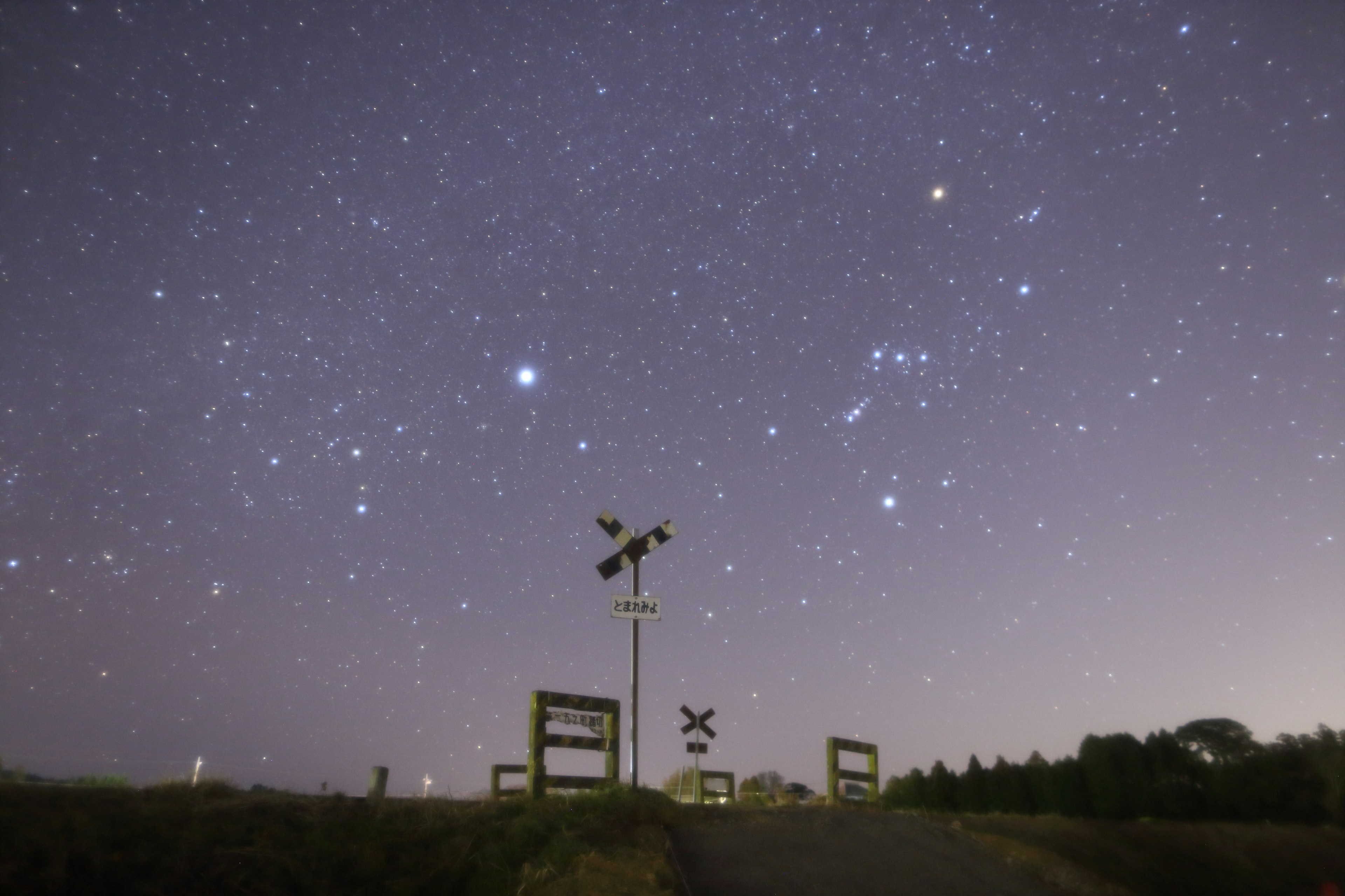 Paesaggio con un segnale ferroviario sotto un cielo stellato