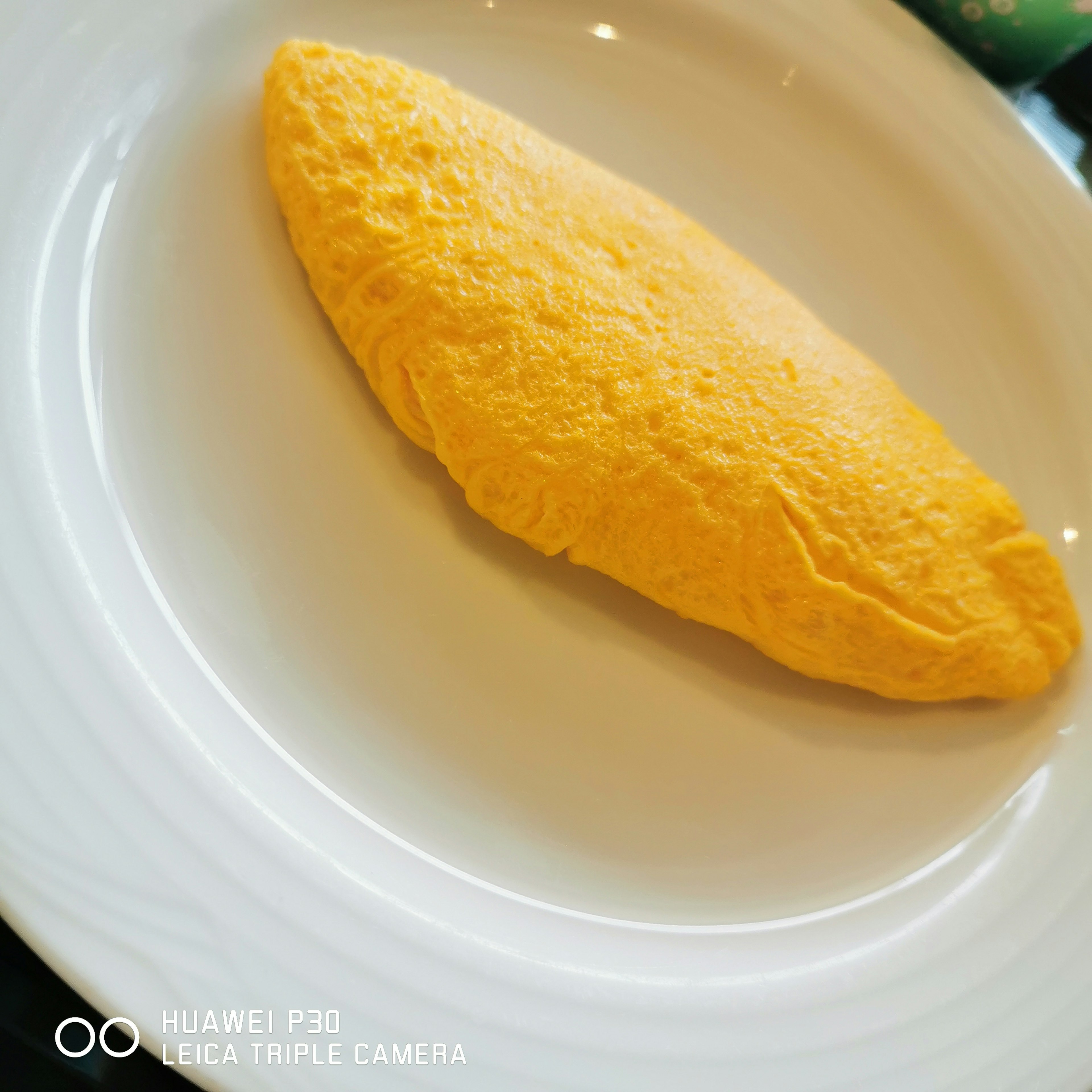 Omelet kuning di atas piring putih