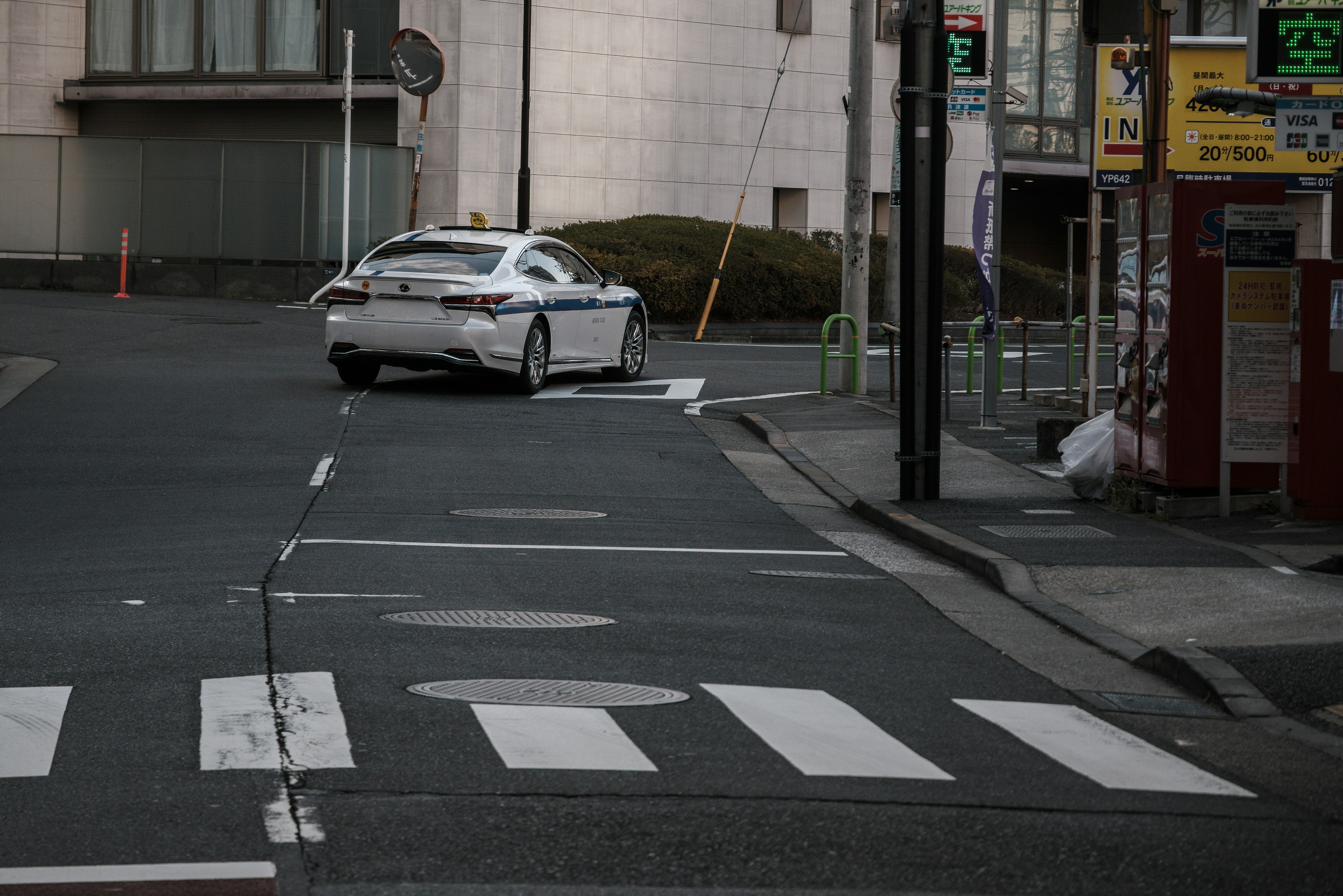 Ein weißes Auto, das an einer Straßenkreuzung in einer städtischen Umgebung abbiegt