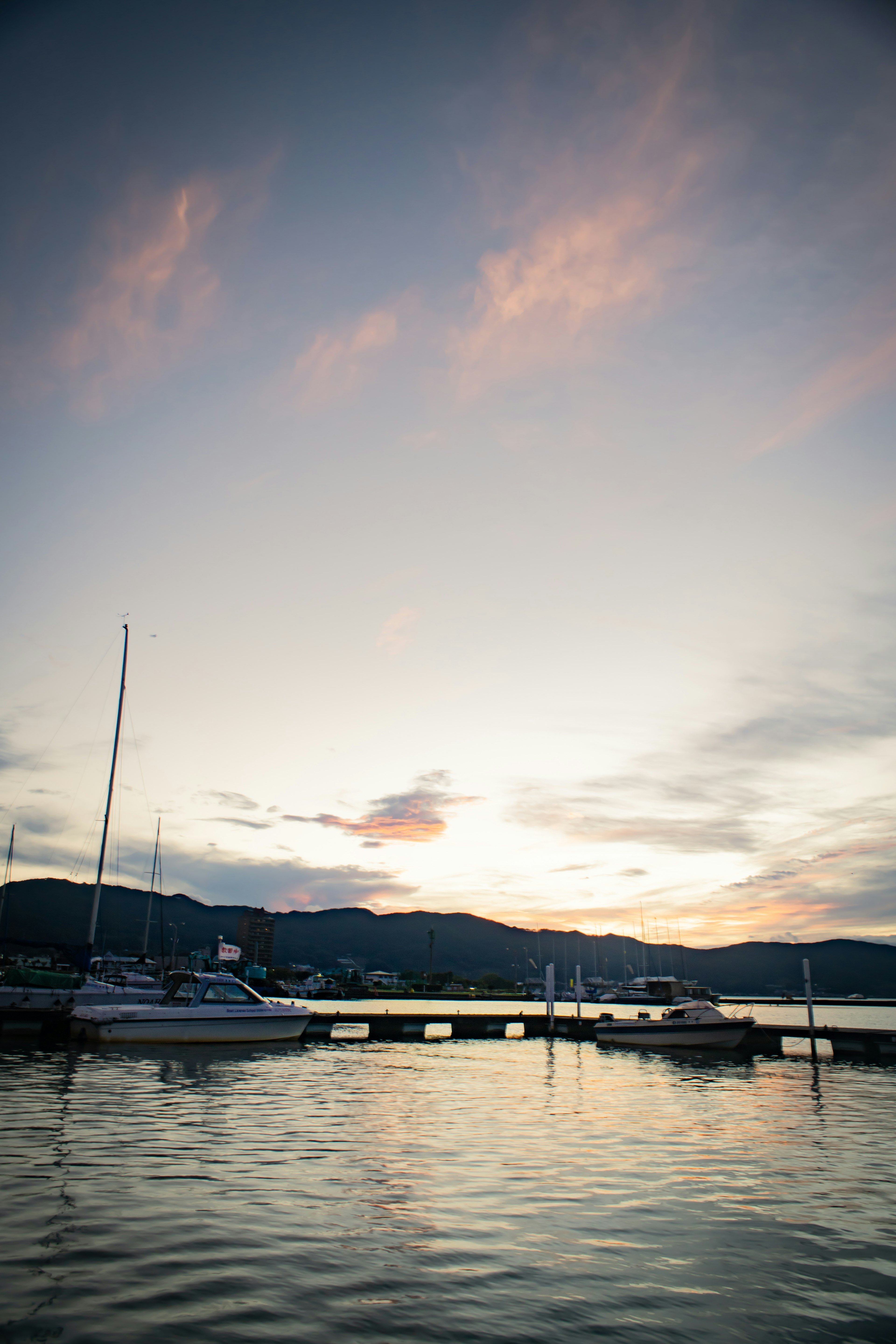 静かな港に浮かぶボートと美しい夕焼けの風景