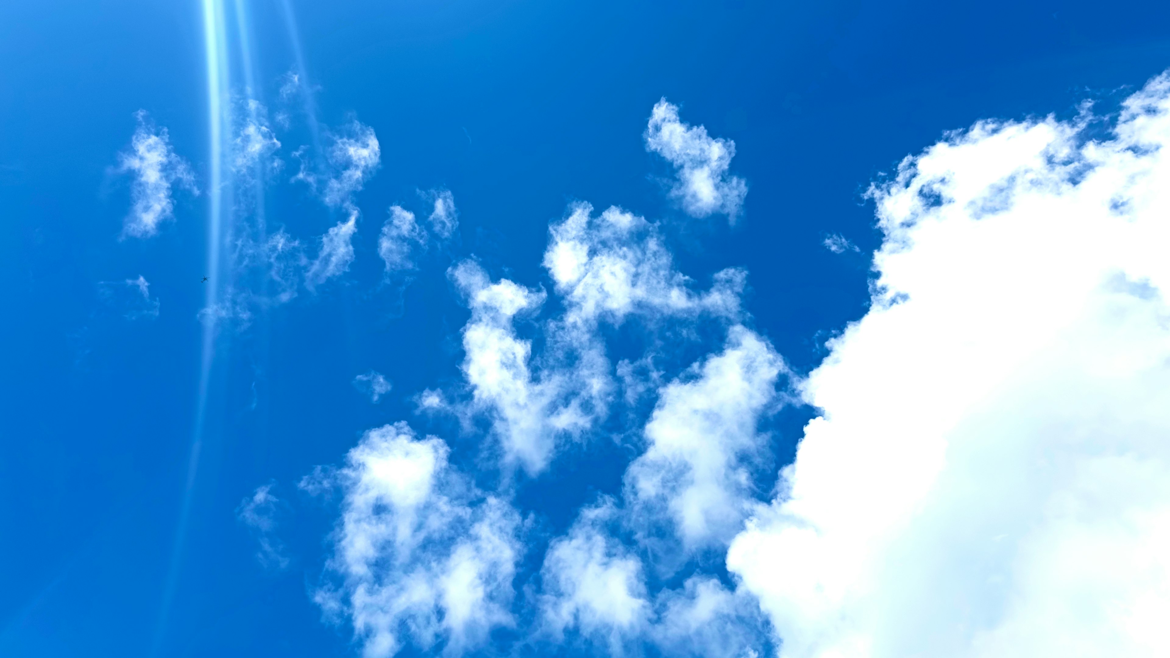 Ciel bleu lumineux avec des nuages blancs duveteux