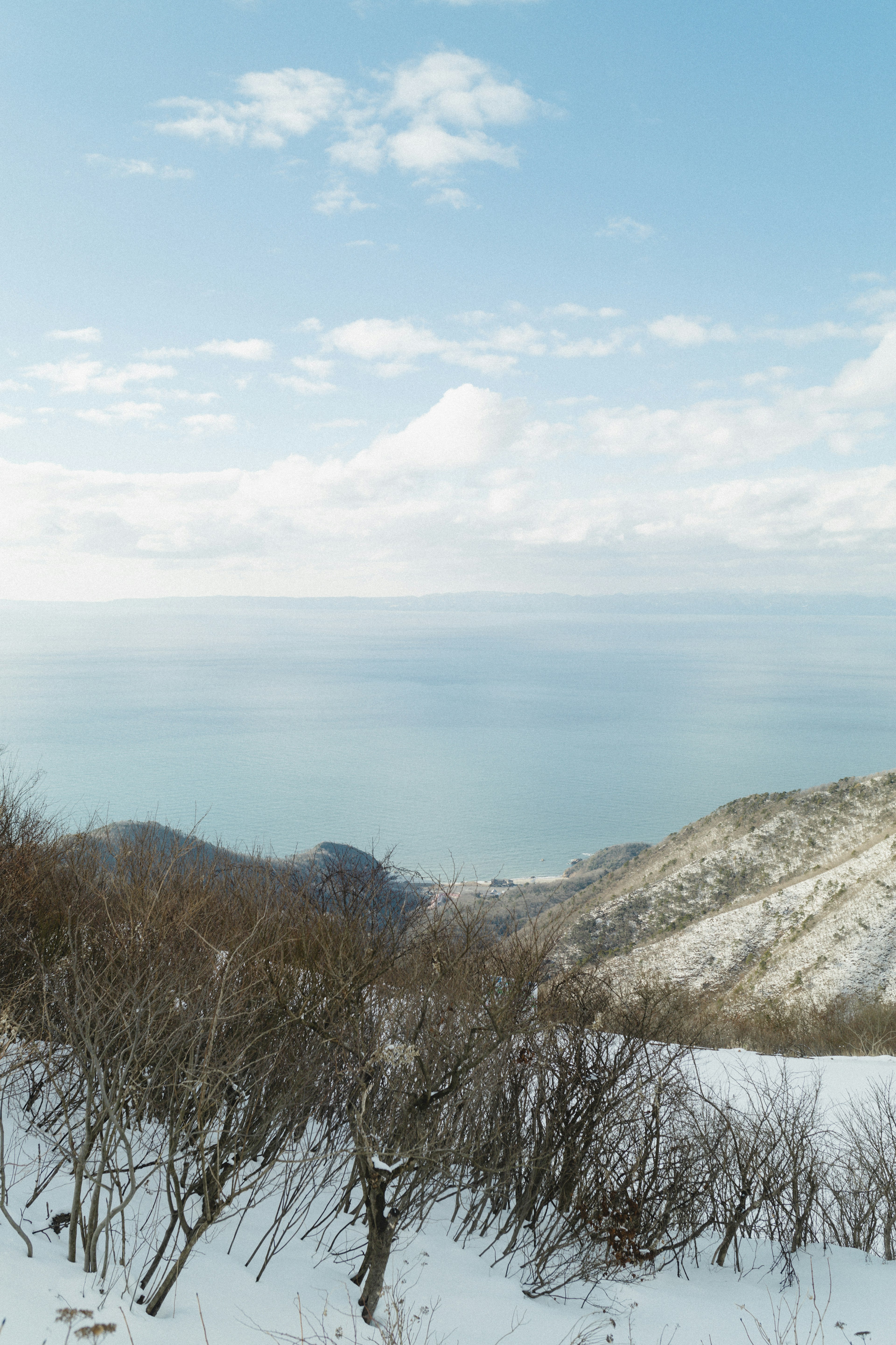 Schneebedeckte Berge mit Blick auf das blaue Meer