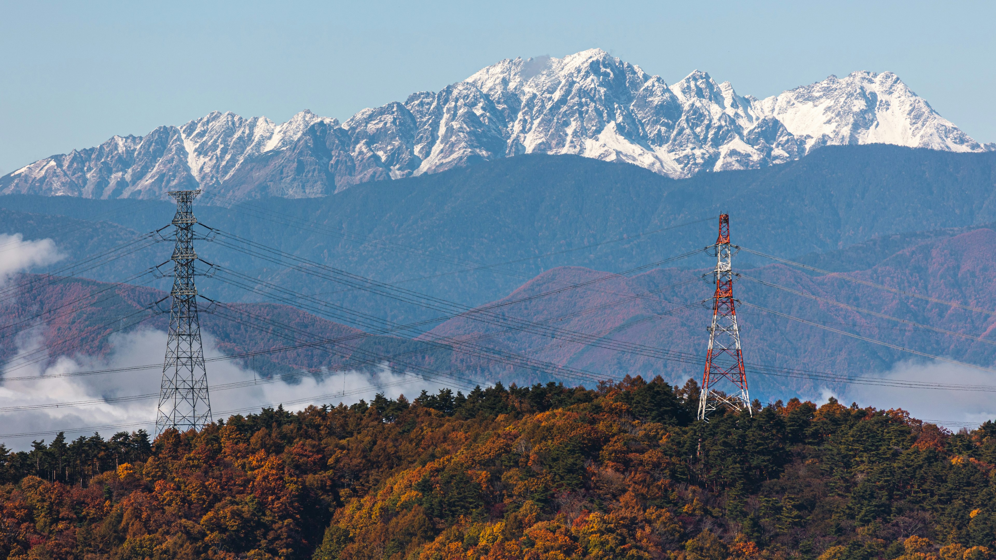 美しい雪に覆われた山々と秋の色合いの木々が見える風景