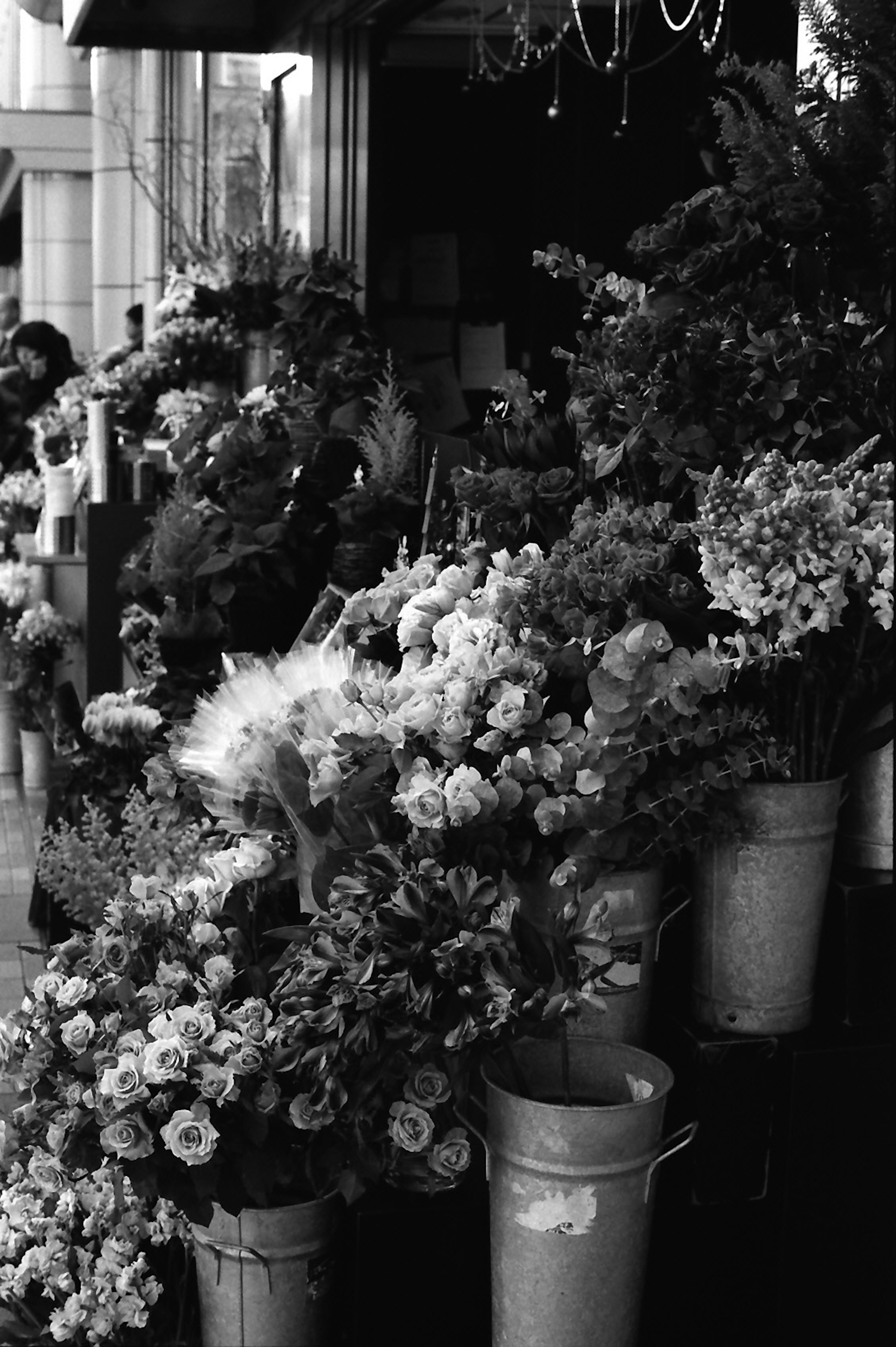 Black and white photo of a flower shop display with various bouquets