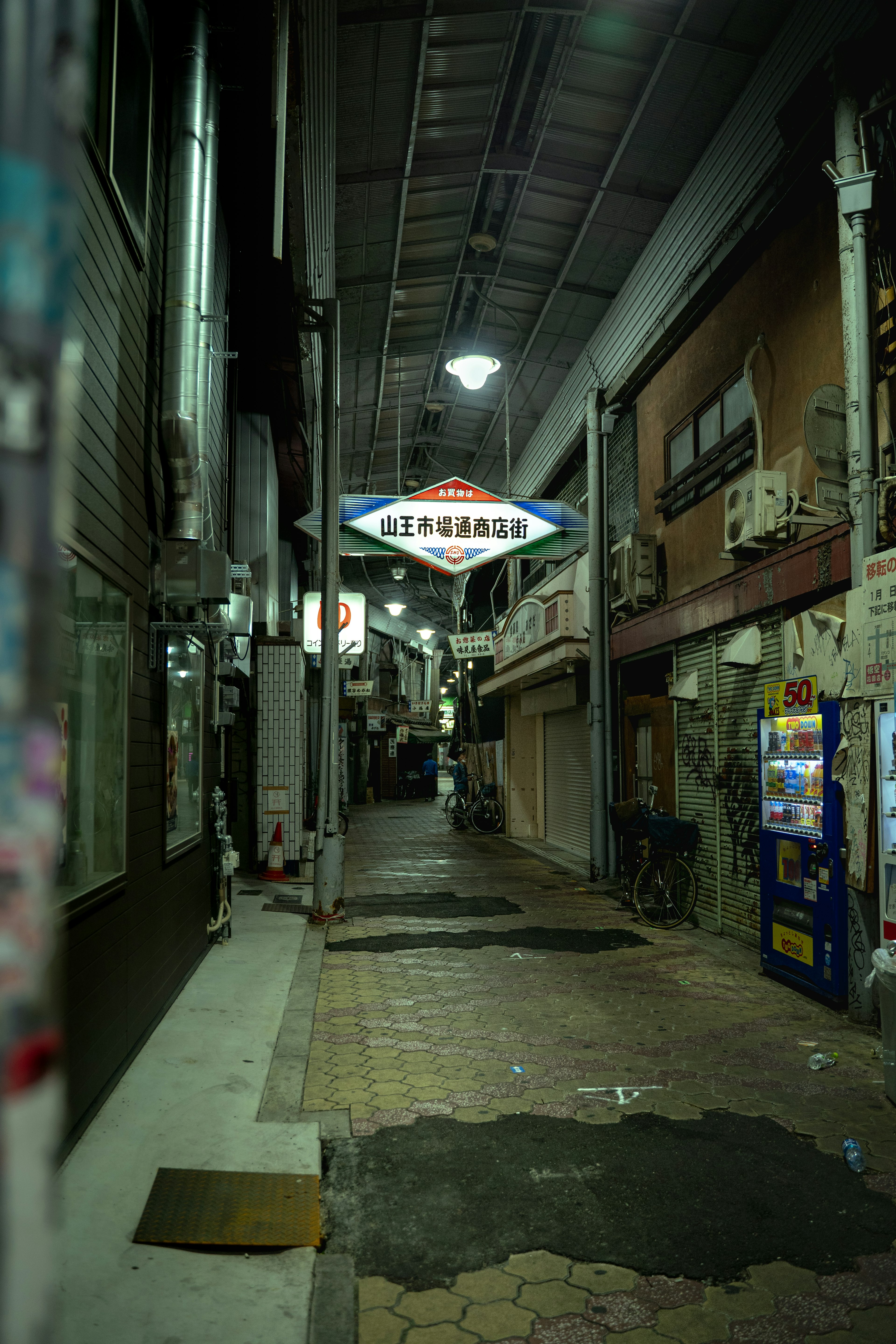 Dimly lit alley with a sign and vending machines