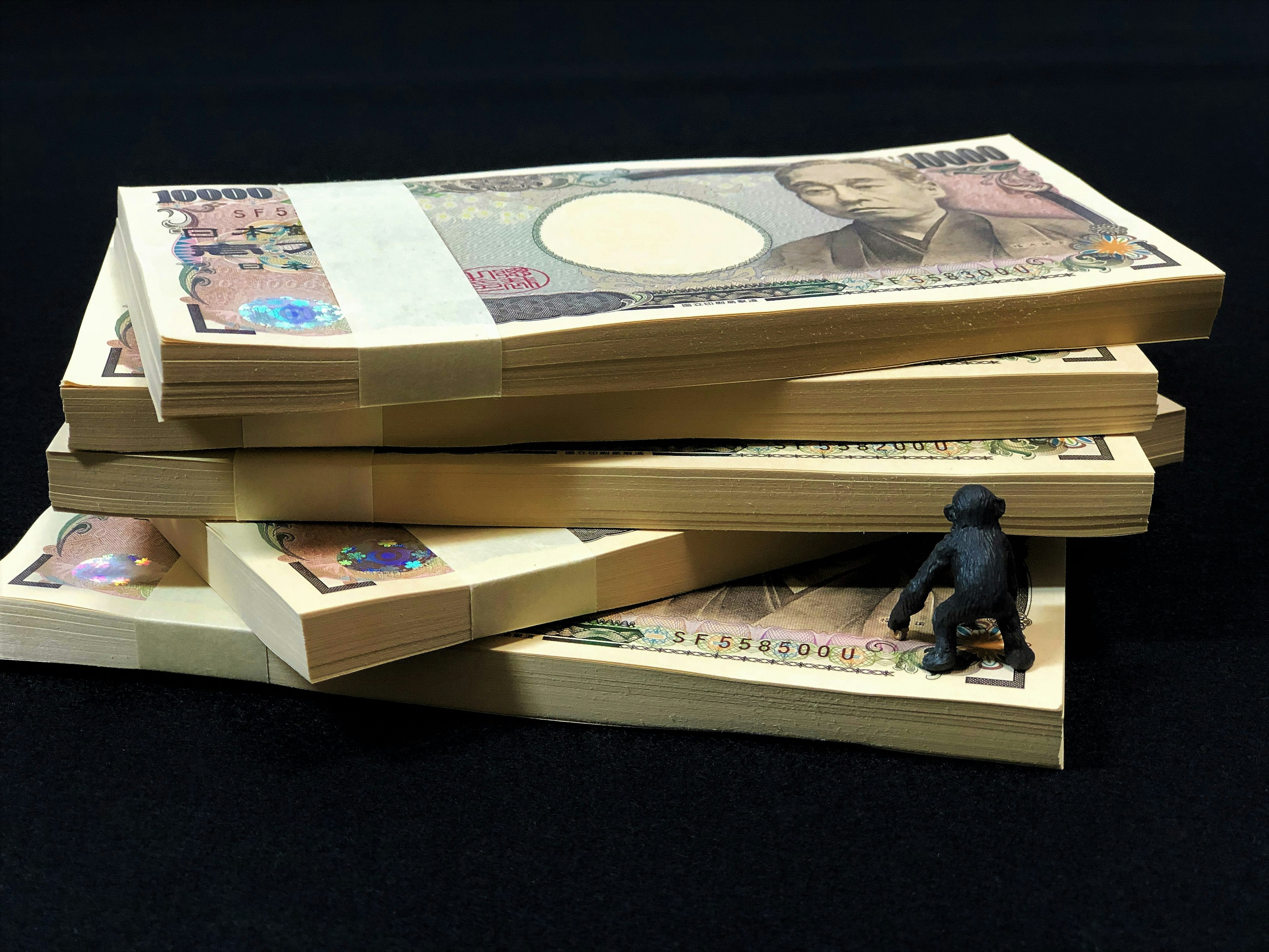 Stapel von japanischen Yen-Banknoten mit einer kleinen Figur oben