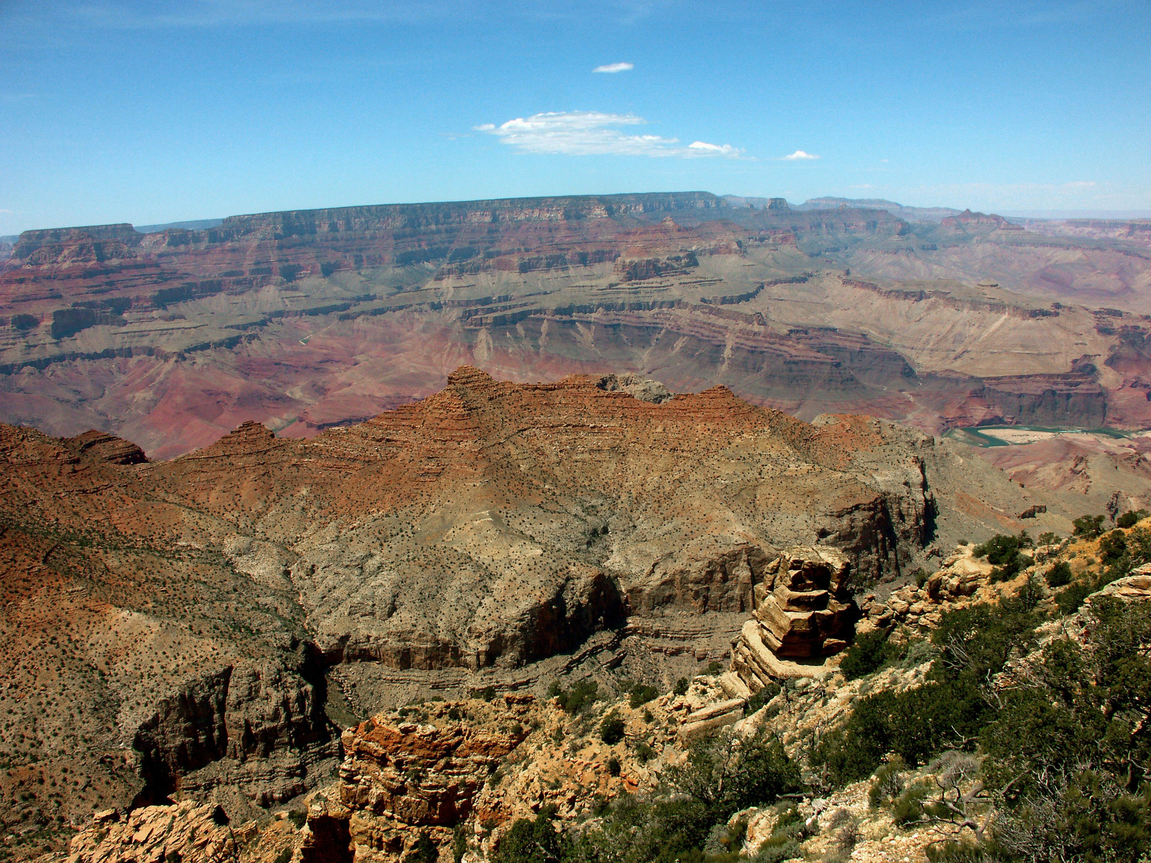 Khung cảnh rộng lớn của Grand Canyon với bầu trời xanh và các lớp đá đỏ