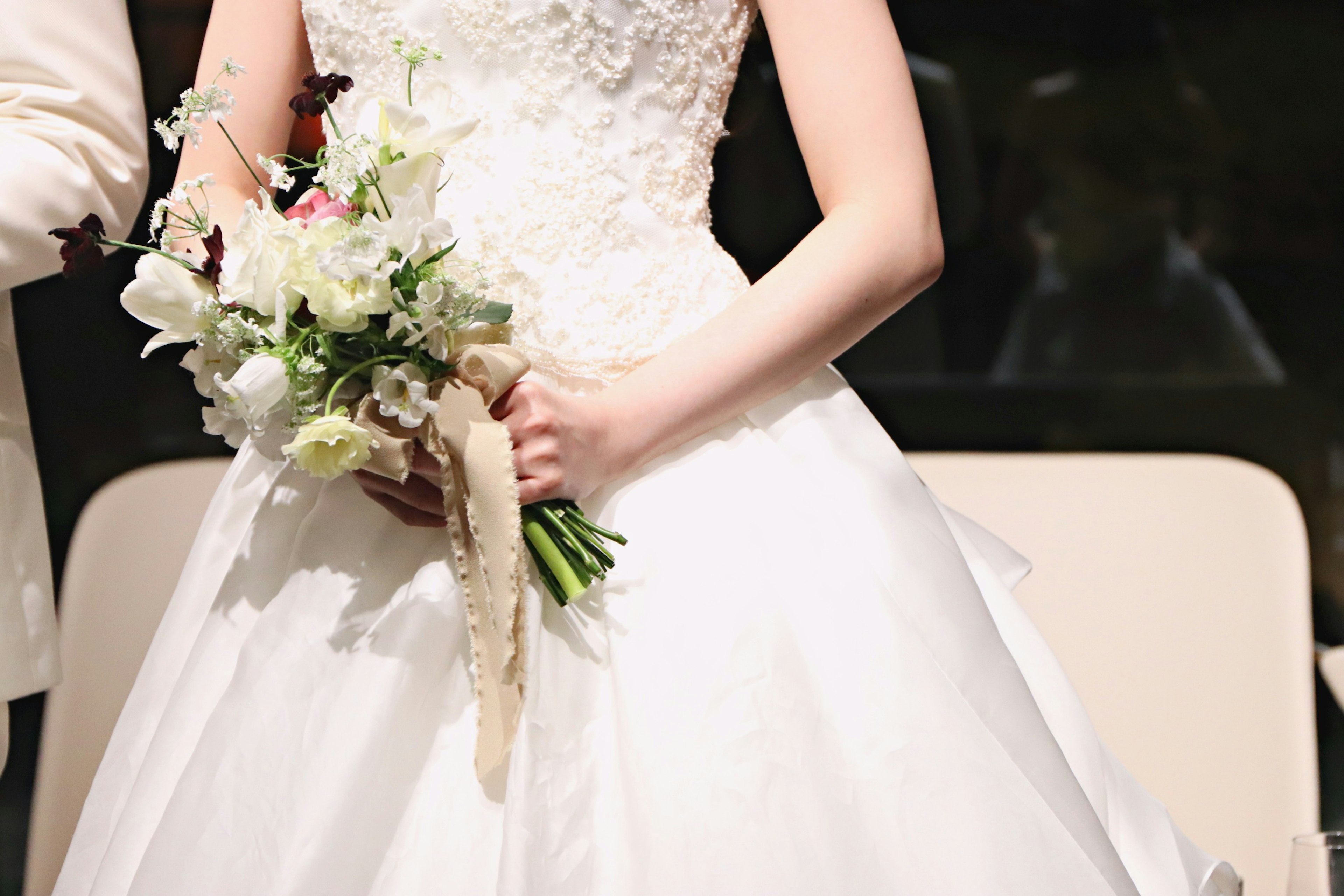 Una donna in abito da sposa che tiene un mazzo di fiori