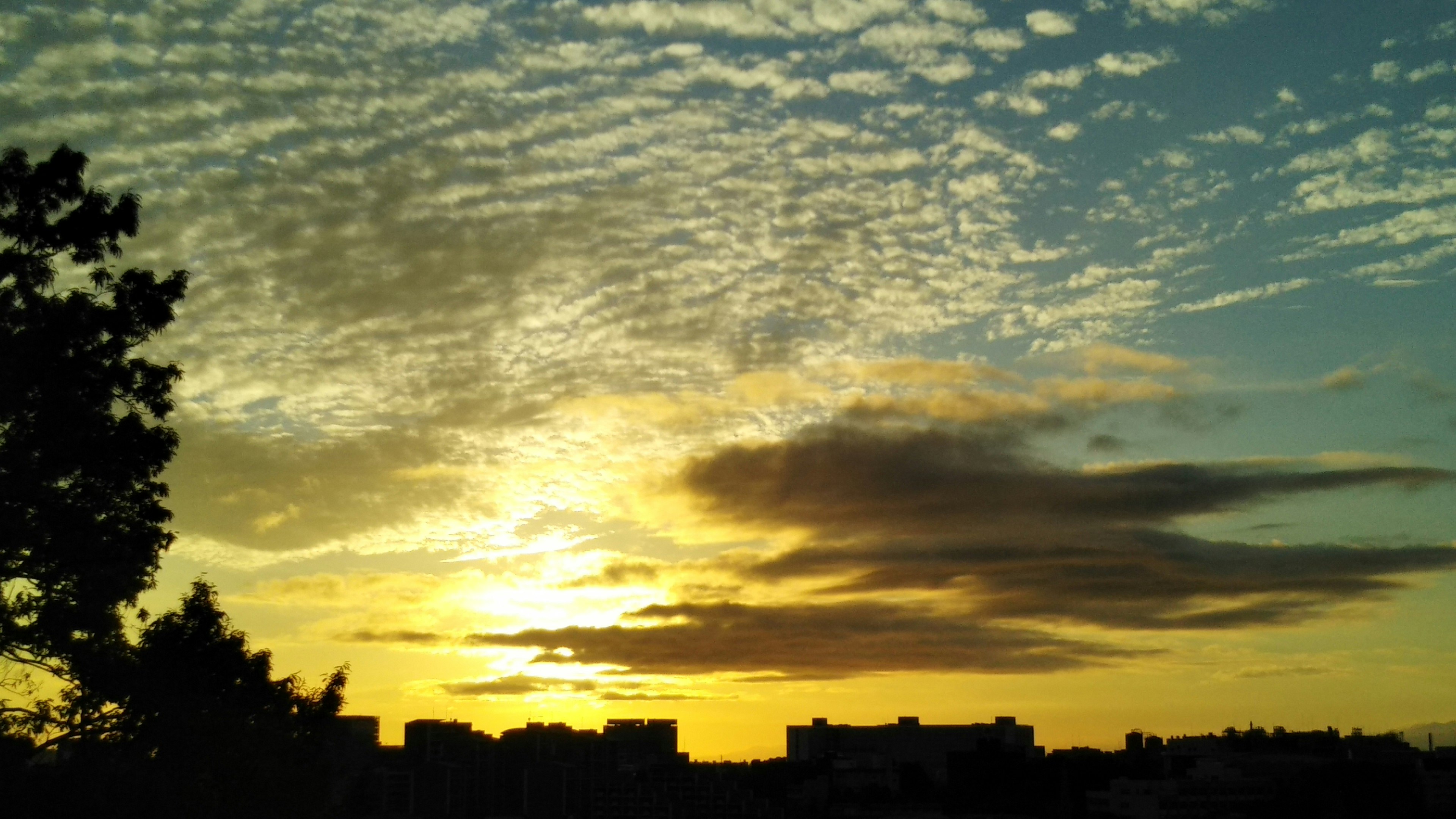 Hermoso atardecer con nubes silueteadas contra edificios