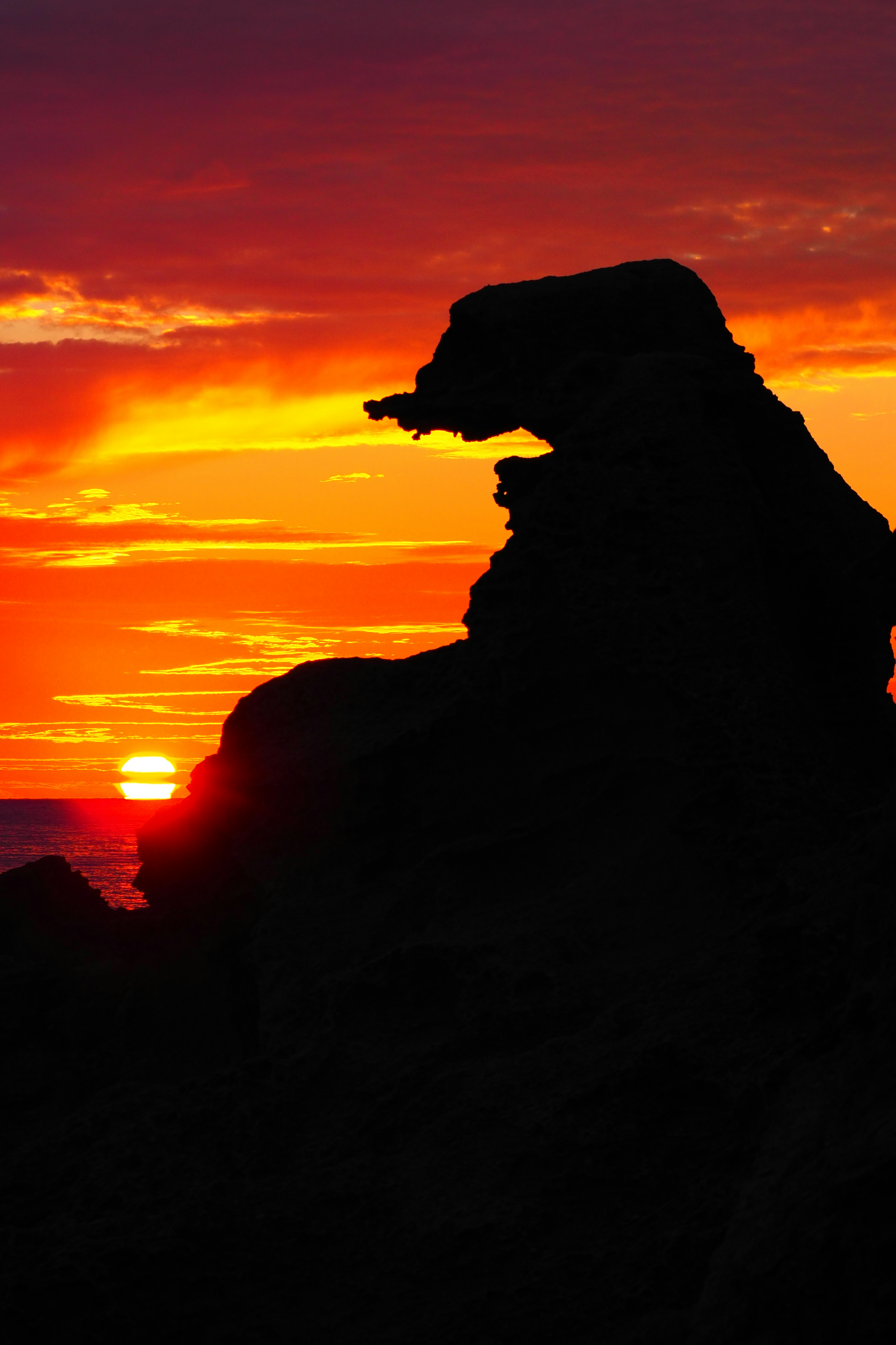 Silhouette of a rock formation against a sunset